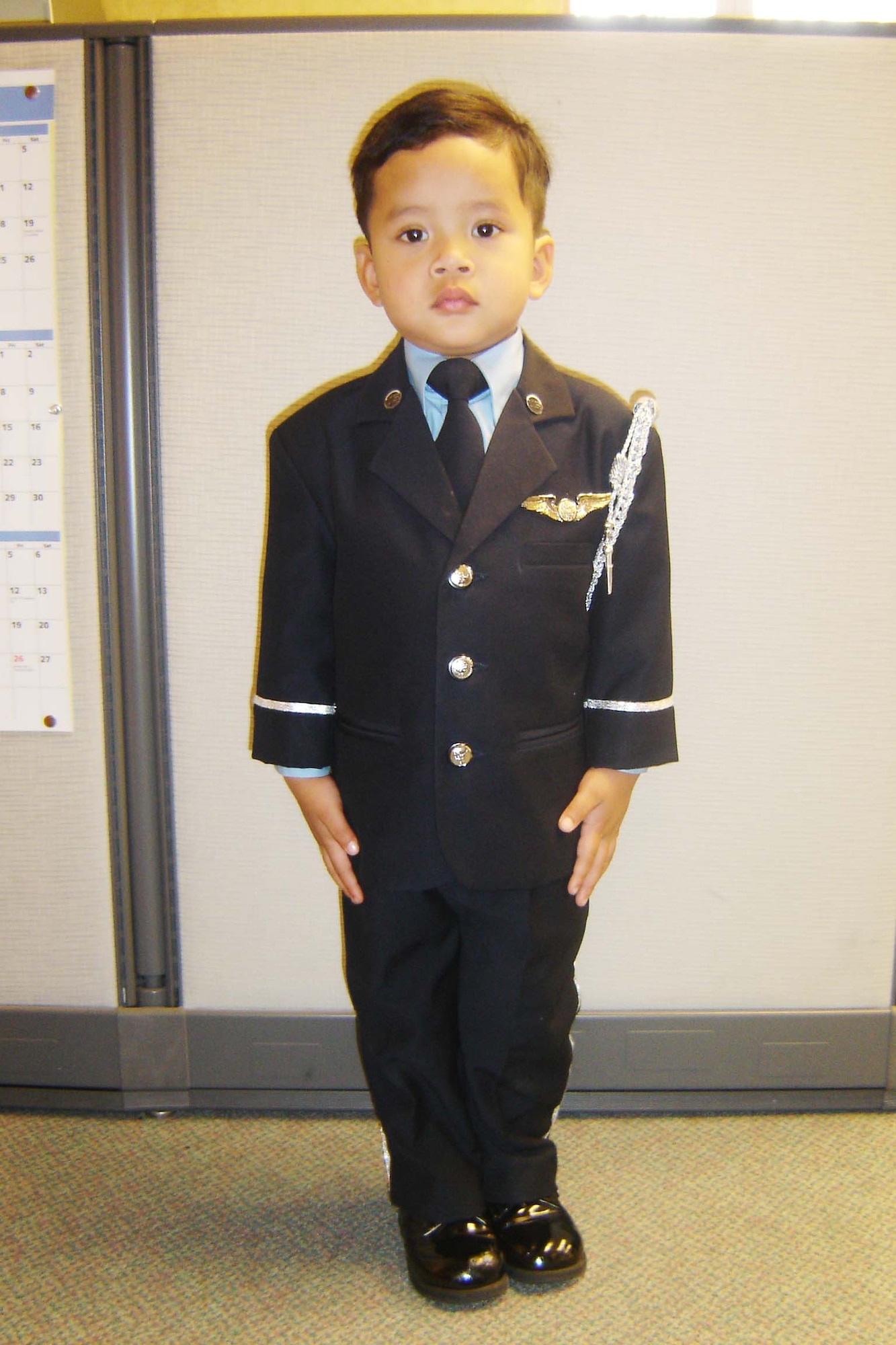 ‘ATTENTION!’   Two-year-old Jacob Vo smartly executes commands given by his uncle, Tech. Sgt. Neil Ballecer, a member of the March Field Honor Guard. Jacob became the Honor Guard’s unofficial mascot this year after Sgt. Ballecer observed him standing at attention and imitating the guard’s movements during official functions. “He’d march around the house at home after the events, or he’d see a military commercial and stand and salute. He even memorized the Star Spangled Banner,” said Sgt. Ballecer. “I didn’t teach him a thing; he did it all himself.” So, the next time Sgt. Ballecer took Jacob to an event - the Annual Honor Guard Banquet in September - he dressed him in a mini “Air Force” Honor Guard uniform. “It was hard to match our Honor Guard uniform, but I bought a little blue suit,” said Sgt. Ballecer. “Then I went to a craft supply store, and I got some piping and sewed it on the wrist of the suit and the side of the pants; I sewed on some old buttons, and I gave him my wings. He’d rather wear that suit than diapers.” (U.S. Air Force photo by Will Alexander)