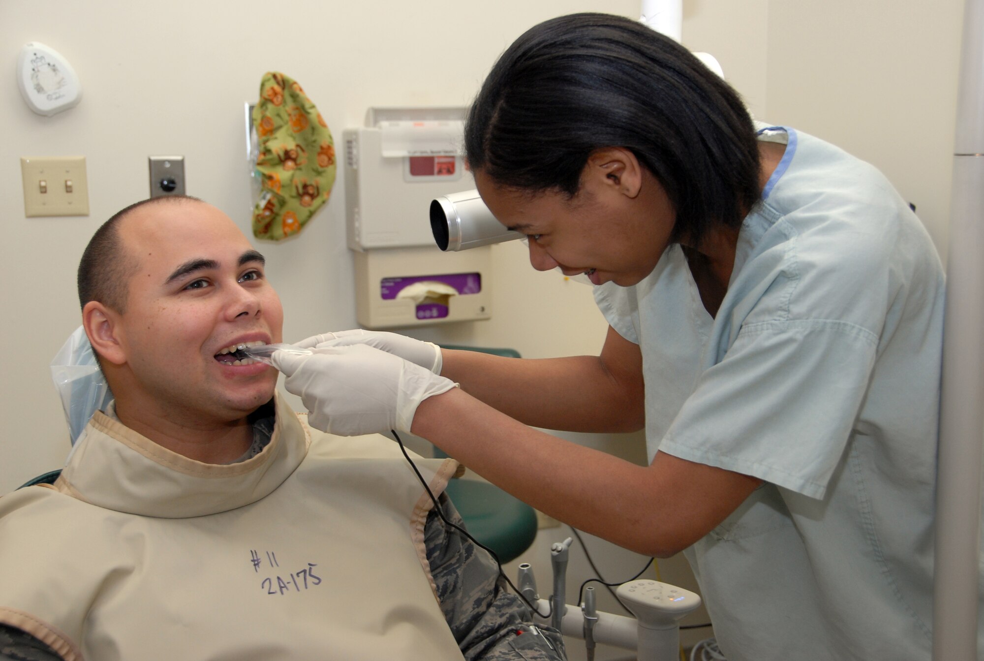 Senior Airman Manual Acuna, 477th Maintenance Squadron, follows specific instructions given by Airman Natasha Williams, 3rd Dental Squadron, during a routine dental x-ray at the 3rd Medical Group on December 13.  The 477th Fighter Group is a Classic Associate unit responsible for recruiting, training, developing and retaining Citizen Airmen to support 3rd Wing and Expeditionary Air Force mission requirements. (U.S. Air Force photo by Staff Sgt. Rhiannon Willard)
