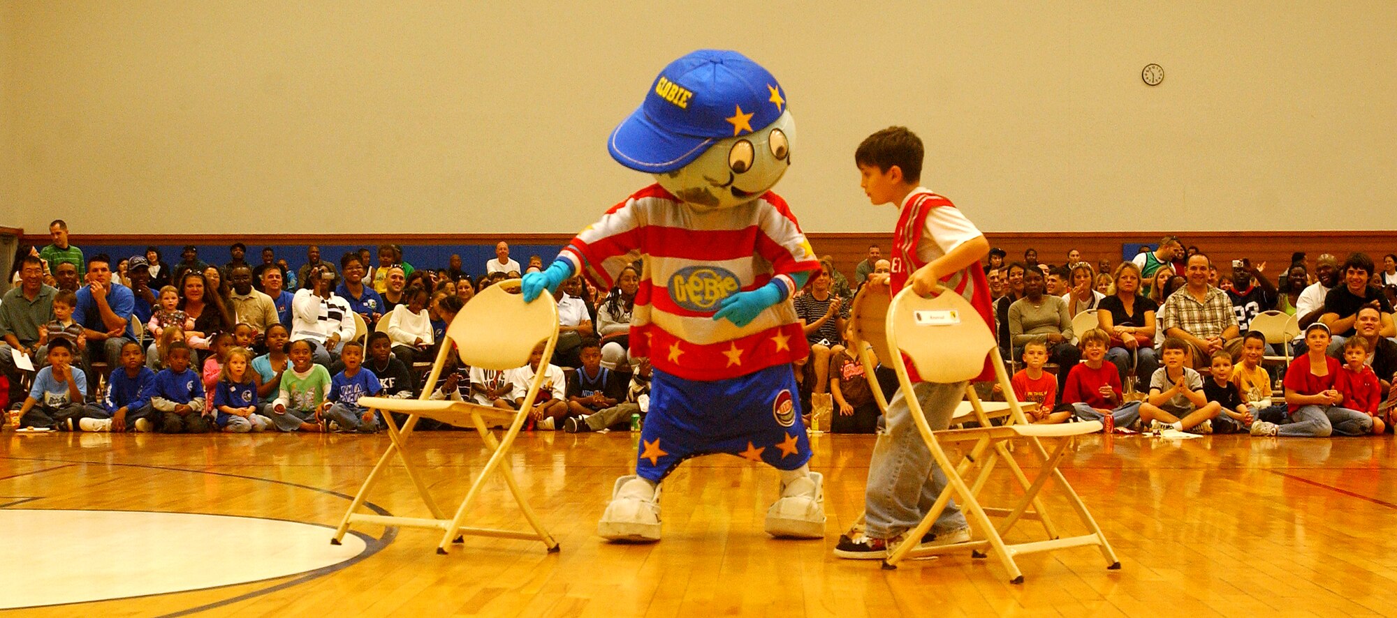 "Globie," the Harlem Globetrotters' official mascot, plays an improvised version of musical chairs with an audience member Dec. 12 at the Risner Fitness Center here. The Harlem Globetrotters play numerous exhibition games around the world during their off-season.
(U.S. Air Force official photo/Staff Sgt. Nestor Cruz)