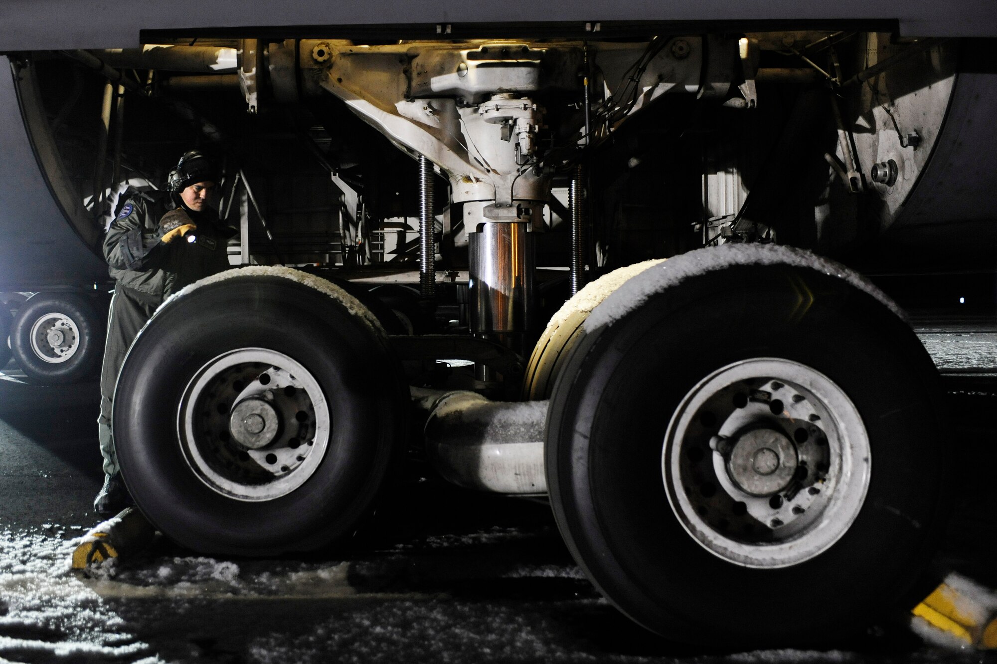 Master Sgt. Jorge Orama checks for leaks on a C-5M Super Galaxy's landing gear after a cold weather test Dec. 14, 2008, Eielson Air Force Base, Alaska. This is the first Galaxy with the new CF-6 engines, pylons and auxiliary power units, with upgrades to the aircraft's skin and frame, flight controls, landing gear and the pressurization system that went through cold weather testing. Sergeant Orama is assigned to the Air Mobility Command Test and Evaluation Squadron, Detachment 1 at Edwards Air Force Base, Calif. (U.S. Air Force photo/Senior Airman Jonathan Snyder)