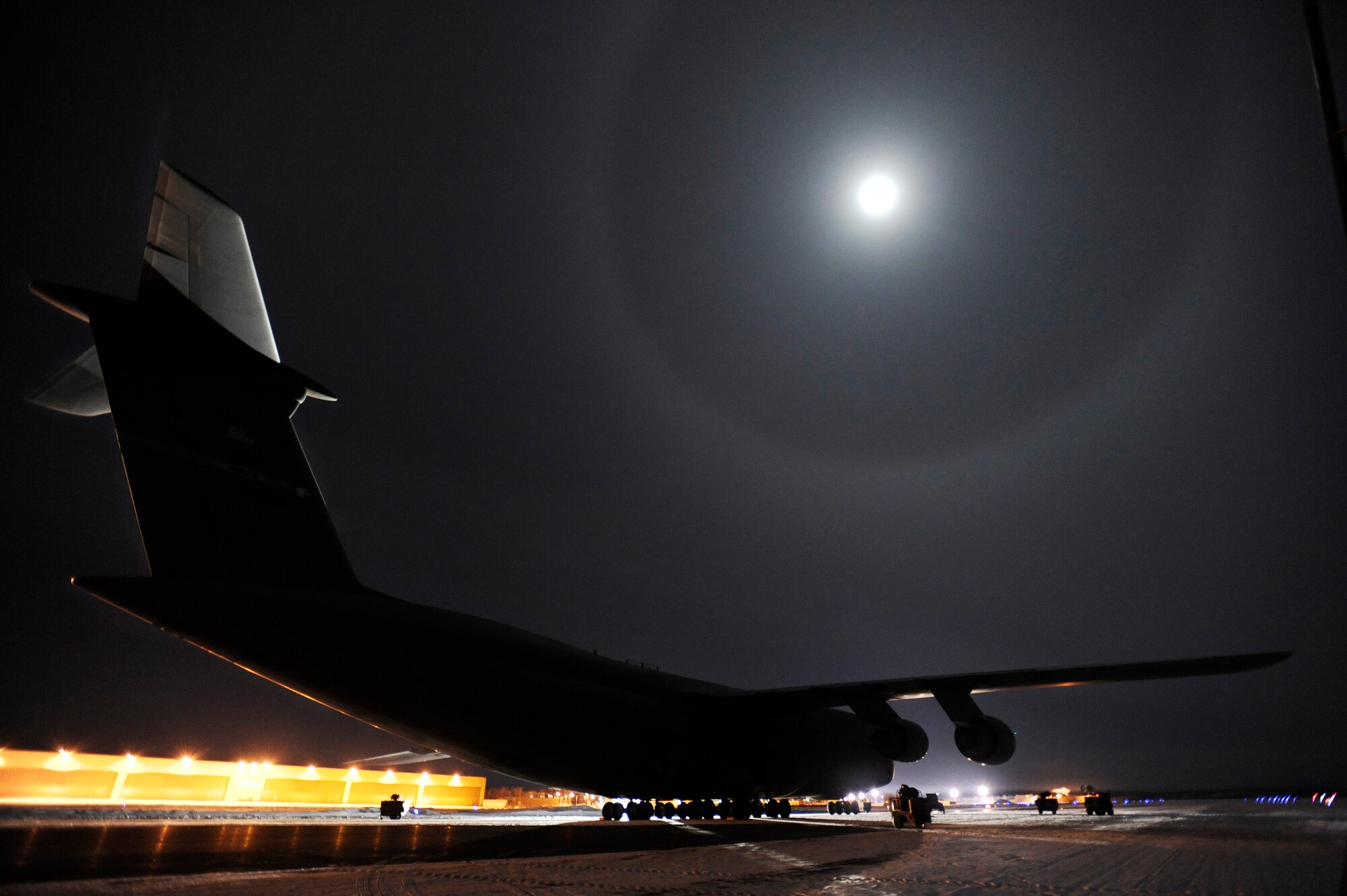 A C-5M Super Galaxy, largest aircraft in the Air Force, is lit by the largest moon of the year while it sits on the tarmac overnight for a period of 24 hours with temperatures low as -25 degrees during cold weather testing Dec. 12, 2008, Eielson Air Force Base, Alaska. This is the first Galaxy with new CF-6 engines, pylons and auxiliary power units, with upgrades to the aircraft's skin and frame, flight controls, landing gear and the pressurization system that went through cold weather testing.  (U.S. Air Force photo/Senior Airman Jonathan Snyder)