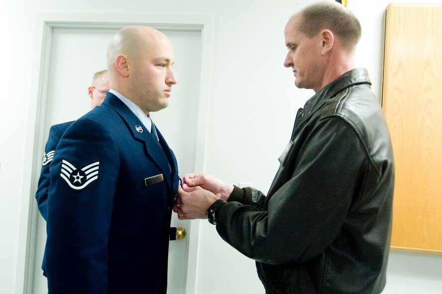 Staff Sgt. David Kechter, 62nd Security Forces Squadron armory NCOIC, left, receives the Purple Heart from Col. Jeffrey Stephenson, 62nd Airlift Wing commander, during a ceremony at the armory here. Sergeant Kechter, a Strasburg, Colo., native, was wounded in November 2007 while conducting a combat patrol in Umm-Qasr, Iraq. At the time of his injury, he was serving as a gunner in a Humvee; his vehicle was struck by an improvised explosive device. He returned from his deployment in May. (U.S. Air Force photo/Abner Guzman)
