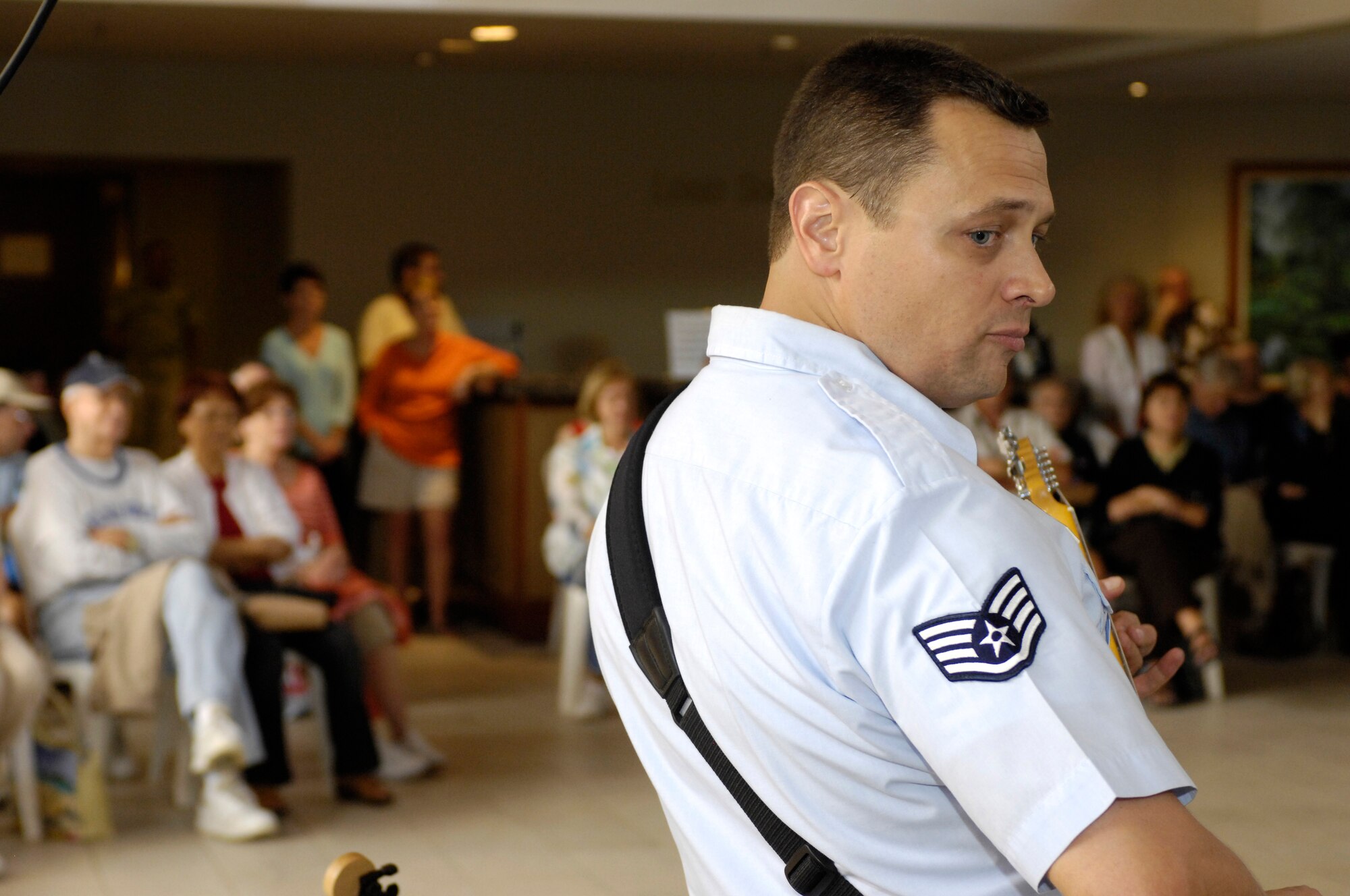 Staff Sgt. Greg Lacy, a native of Dallas, Texas and a member of the U. S. Air Force Band of the Pacific-Hawaii looks back at fellow band members while entertaining more than fifty guests in the lobby of the Hale Koa military resort on Dec. 11, 2008. The band performs at the Hale Koa for at least one show during the holiday season every year. (U.S. Air Force photo by Tech Sgt. Cohen A. Young/Released)