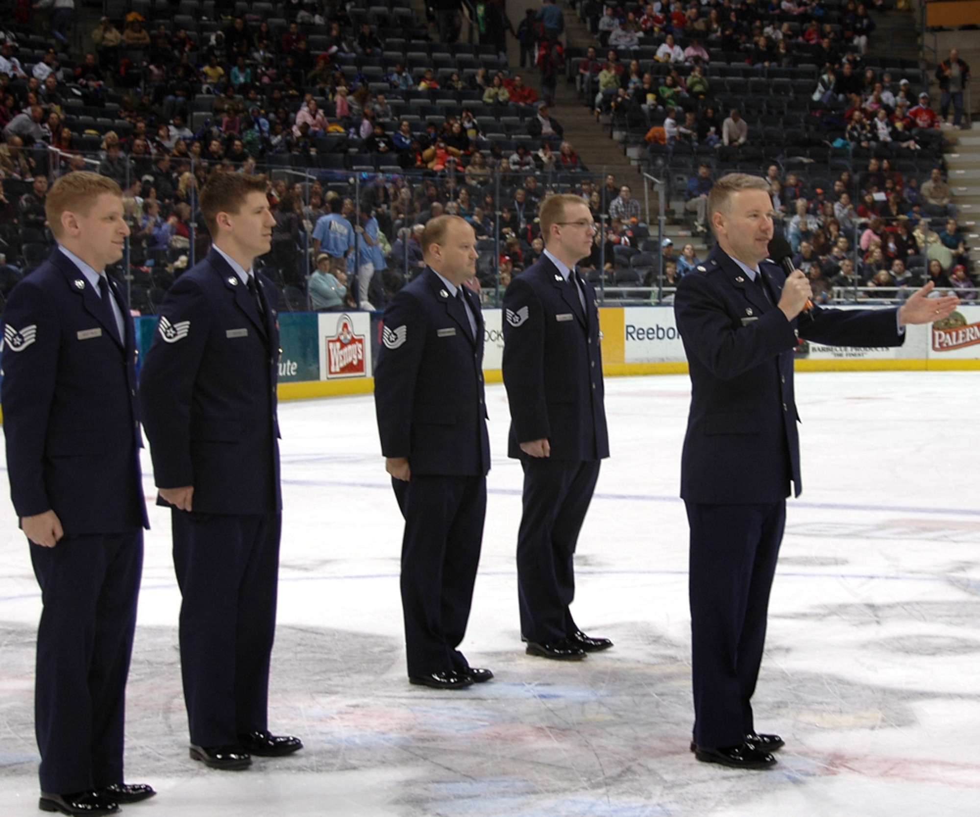 Lt. Col Jerome T. Traughber, right, 347th Recruiting Squadron commander, administered the Oath of Enlistment to 20 Delayed Entry Program members Dec. 12 in the Milwaukee, Wisc., Bradley Center. The event was made possible by a partnership between the 347th RCS and the American Hockey League’s Milwaukee Admirals. Squadron recruiters stand behind the commander in support of the event. (U.S. Air Force photo/Staff Sgt. Joseph Hansen)