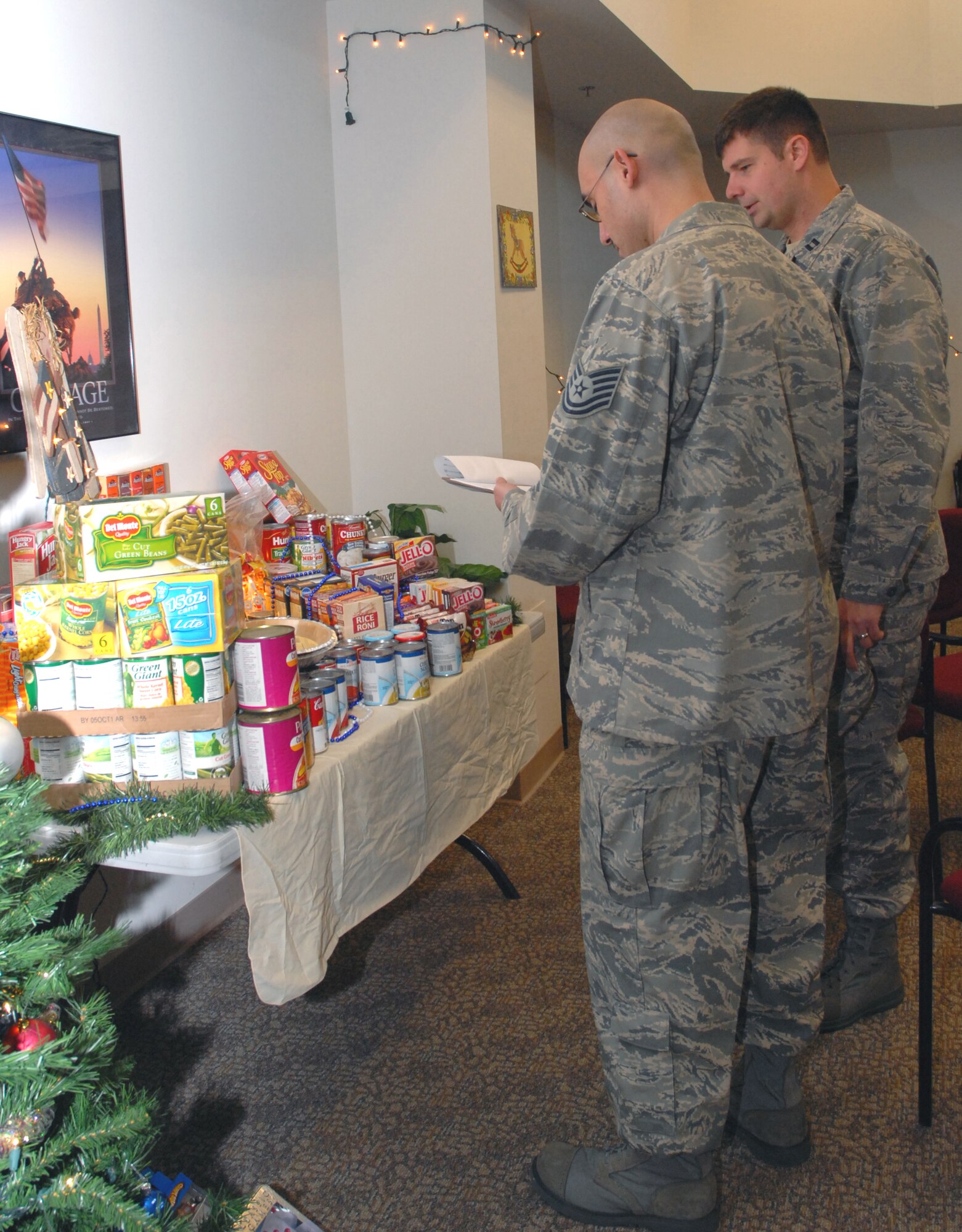 BEALE AIR FORCE BASE; Calif. -- Air Force Reservist Capt. Jason Bredeson; 940th Air Refueling Wing chaplain, judges the best display for the wing's annual holiday food drive Dec. 7, 2008, as chaplain assistant Tech. Sgt. John Florendo takes notes. 940th ARW units got an opportunity to win a trophy and bragging rights for the best display. The 940th Logistics Readiness Squadron won this year's contest for the best display. The event is sponsored by the 940th Booster Club to help wing family members and various local charitable organizations during the holiday season.; (U.S. Air Force photo/Tech. Sgt. Luke D. Johnson)