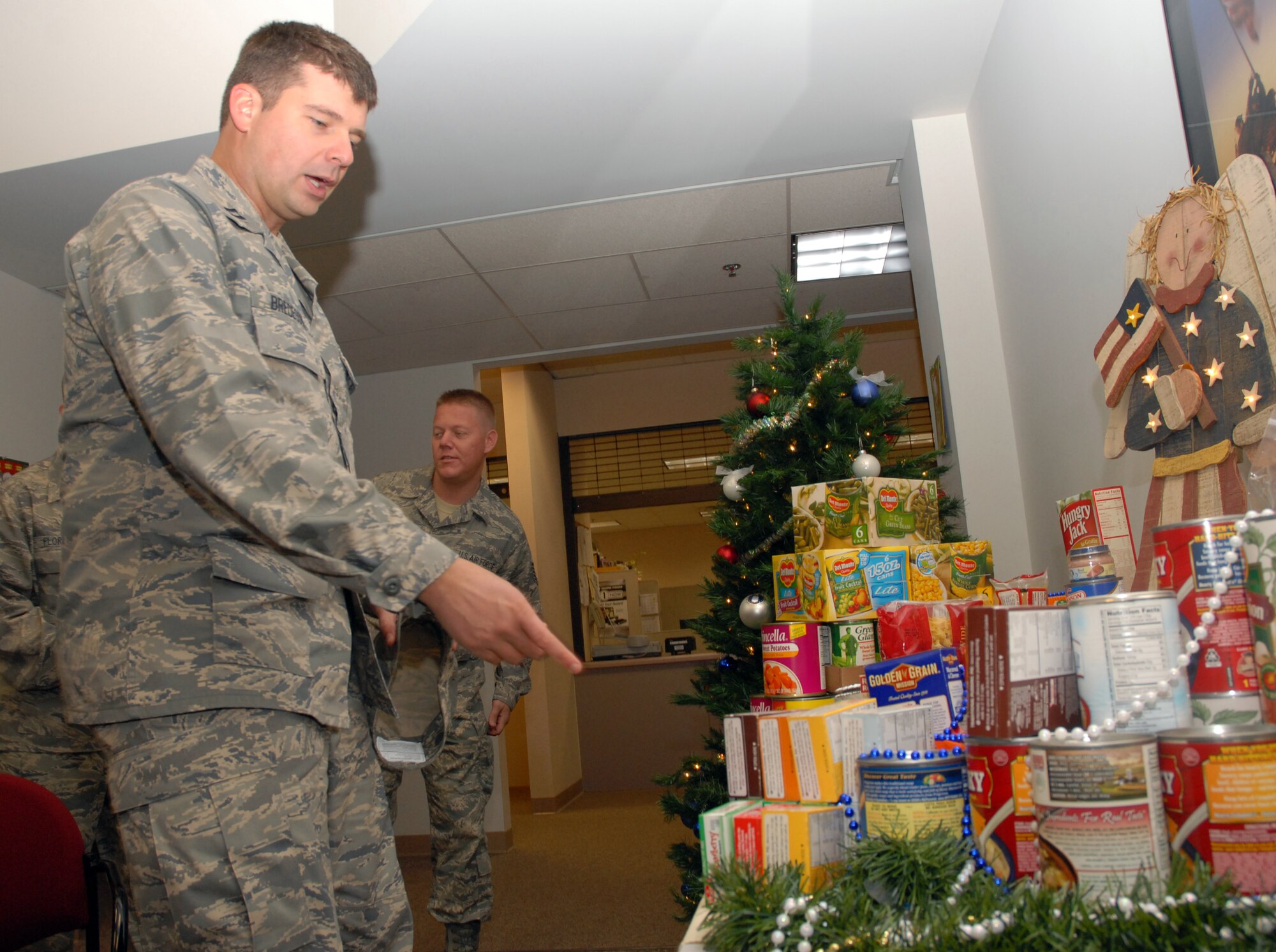 BEALE AIR FORCE BASE, Calif. -- Air Force Reservist Capt. Jason Bredeson, 940th Air Refueling Wing chaplain, points out various food items while judging the best display during wing's annual holiday food drive Dec. 7, 2008. 940th ARW units got an opportunity to win a trophy and bragging rights for the best display. The 940th Logistics Readiness Squadron won this year's contest for the best display. The event is sponsored by the 940th Booster Club to help wing family members and various local charitable organizations during the holiday season. (U.S. Air Force photo/Tech. Sgt. Luke D. Johnson)
