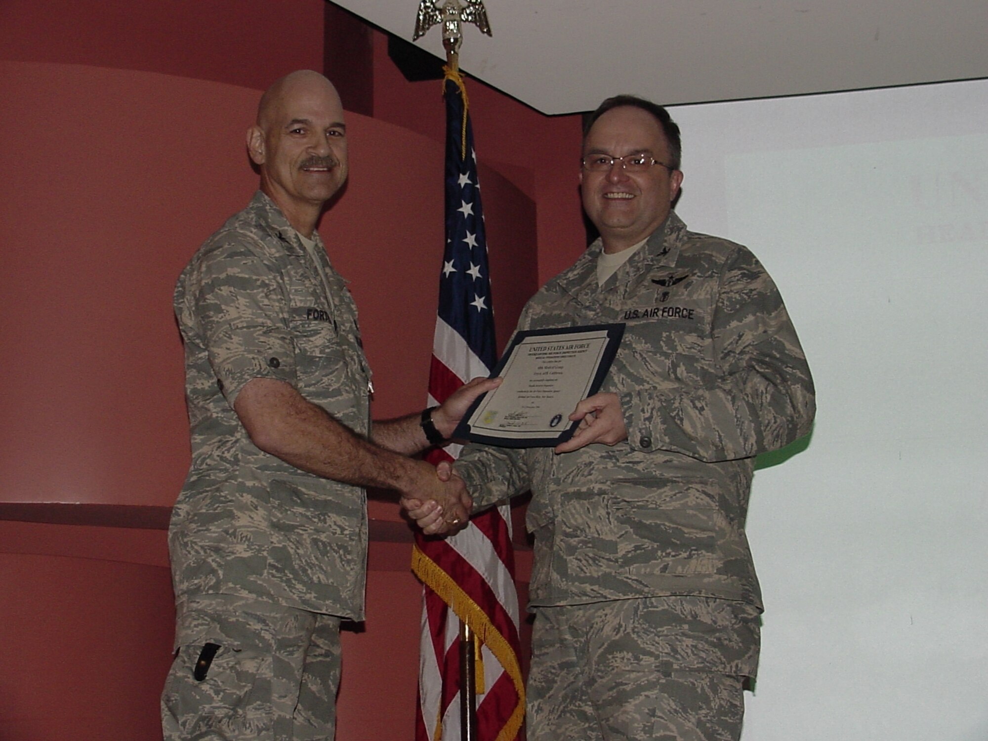 Col. Gary Forthman, director of the Air Force Inspection Agency’s Healthcare Services Inspection team presents the AFIA’s certificate of approval to Dr. (Col.) Lee Payne, 60th Medical Group commander during the HSI Outbrief held in the David Grant USAF Medical Center auditorium (U.S. Air Force photo/Jim Spellman)