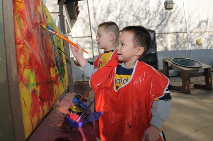 James O'Campo, front, and Braylen Hobeck paint, Nov. 12, outside one of Randolph’s Child Development Centers. (U.S. Air Force photo by Melissa Peterson)