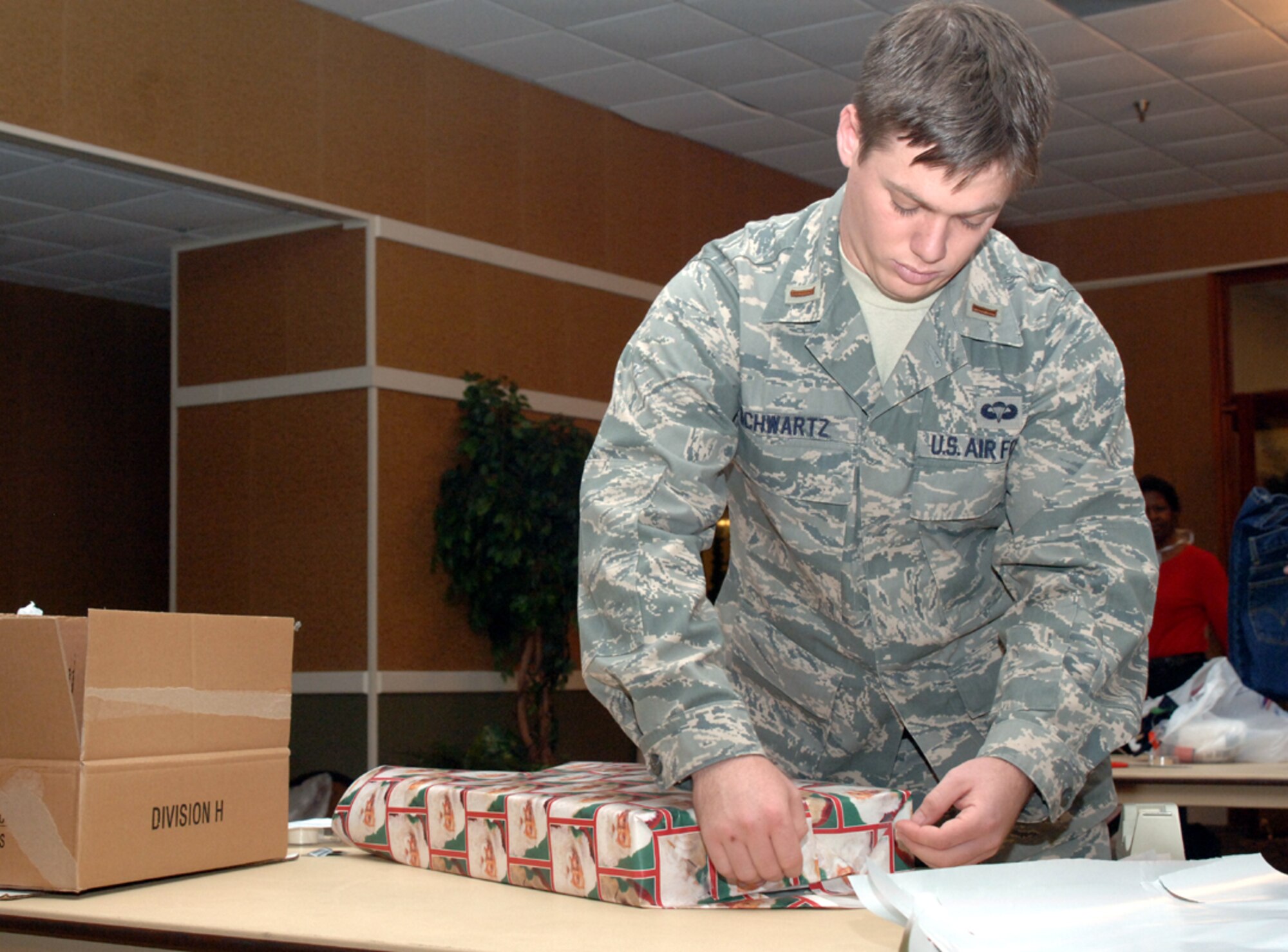 Second Lt. Michael Schwartz, 14th Operations Support Squadron, wraps gifts for children during the Happy Shop and Wrap Wednesday at the Columbus Club. More than 90 volunteers were on hand to assist in the wrapping of presents to donate to local children. (U.S. Air Force photo by Airman Josh Harbin)