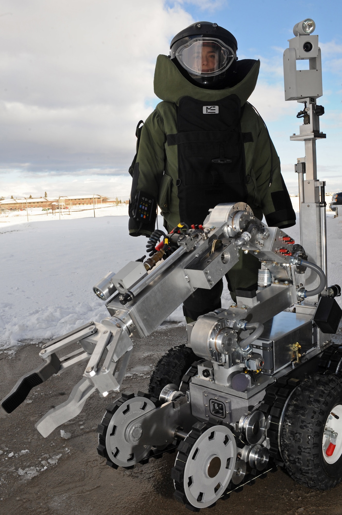 Senior Airman Alicia Goodner, 28th Civil Engineer Squadron Explosive Ordinance Disposal operator, stands beside a ANDROS F6A Robot here, Dec. 11. The robot is equipped with several television cameras for remote viewing and a dexterous arm for hazardous tasks. (US Air Force photo/Airman 1st Class Corey Hook)