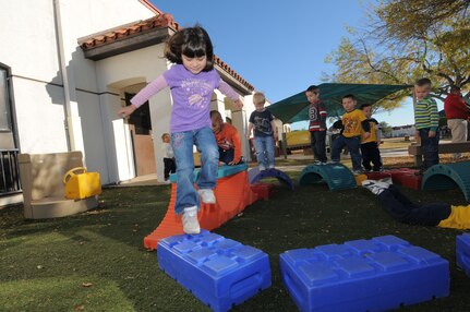 Micah Prada leads other children around a home-made walkway designed by the kids during time outside, Nov. 12, at one of Randolph Air Force Base’s Child Development Center. (U.S. Air Force photo by Melissa Peterson)