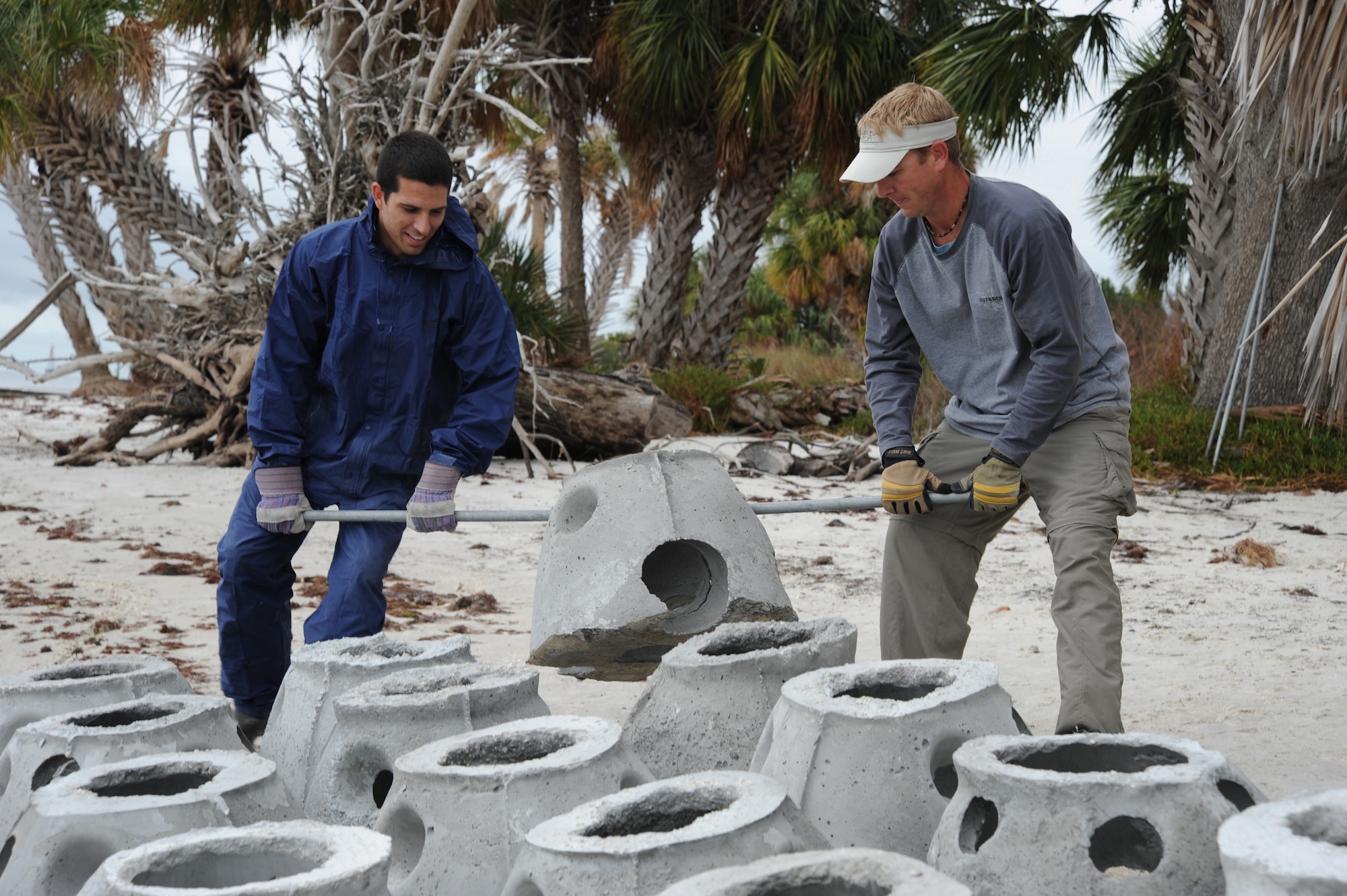 Staff Sgt. Kevin Rocha, 6th Force Support Squadron along with Chris Sutton from the Tampa Bay Watch Incorporated, install oyster habitats along the shoreline during Oyster Reef Project here Dec. 12. This is a continuation of a community-based restoration project that began in 2003. These Oyster shell bars are marine-friendly, hollow, concrete oyster domes that will provide shoreline stabilization for the currently eroding coastline and habitat for marine life. Oyster dome communities provide envoirmental enhancement in the form of hard-bottom habitats for fish and wildlife resources. The goal of the Tampa Bay Watch?s Community Oyster Reef Enhancement program is to increase the oyster population in the Tampa Bay and at the same time, provide habitats for small organisms, prevent shoreline erosion, improve water quality and promote fish and wildlife habitats. The CORE programs primarily use two types of material to construct oyster habitats: Lo-Pro Reef balls and Oyster shell bags.  This project benefits the Tampa Bay community by promoting environmental awareness and offers a hands-on experience in habitat restoration. 