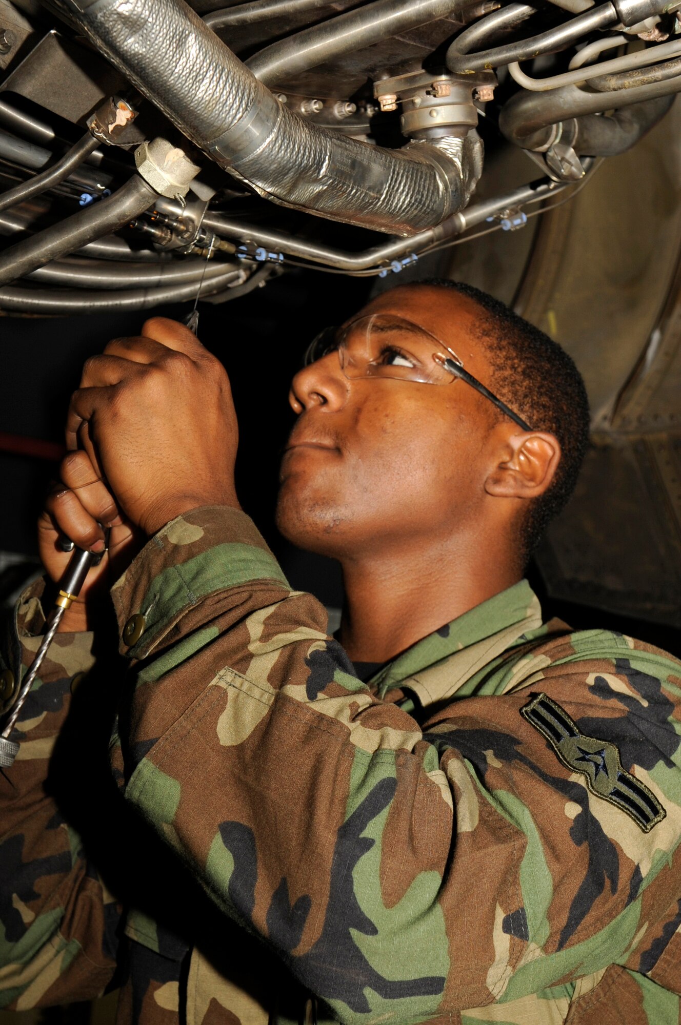 Airman 1st Class Xavier Owens, 6th Maintenance Squadron Aircraft Electrician twist wires together with pliers to finish the installation of an overheat fire detector located in engine four of a KC135 from Andrews AFB, Va. here, Dec. 11 in Hangar two. The KC135 has been here a week for a periodic inspection after being grounded for two months at Andrews due to shortage of personnel. The aircraft was granted a one time flight to MacDill in order to have the periodic inspection conducted faster, saving time and using manpower efficiently, all part of the Air Force Smart Operations for the 21st Century strategy. A KC135 receives two periodic inspections every five years. This inspection was completed in five days compared to three weeks with teamwork of 24 Airmen: 16 active duty from MacDill, four Reserve from the 927th Air Refueling Wing and four Airmen from Andrews.