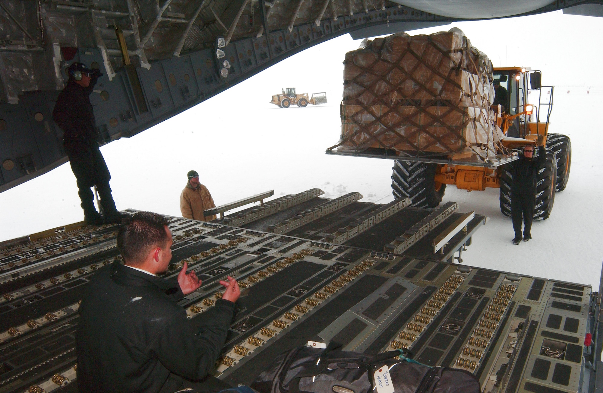 Staff Sgt. Paul Garcia (bottom left) ensures cargo is safely loaded onto a C-17 Globemaster III prior to the return trip to Christchurch, New Zealand, during an Operation Deep Freeze mission Dec. 2. Sergeant Garcia is a 7th Airlift Squadron loadmaster from McChord Air Force Base, Wash. (U.S. Air Force photo/Staff Sgt. Eric Burks) 
