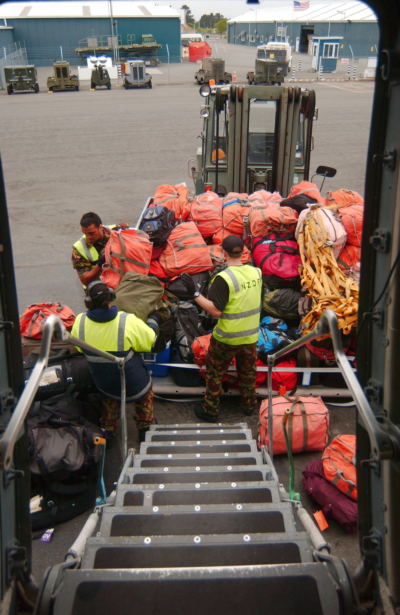 Members of the New Zealand Defence Force prepare to load baggage on a C-17 Globemaster III prior to an Operation Deep Freeze mission to Antarctica Dec. 1. The Airmen and the C-17 Globemaster III are from McChord Air Force Base, Wash. (U.S. Air Force photo/Staff Sgt. Eric Burks) 
