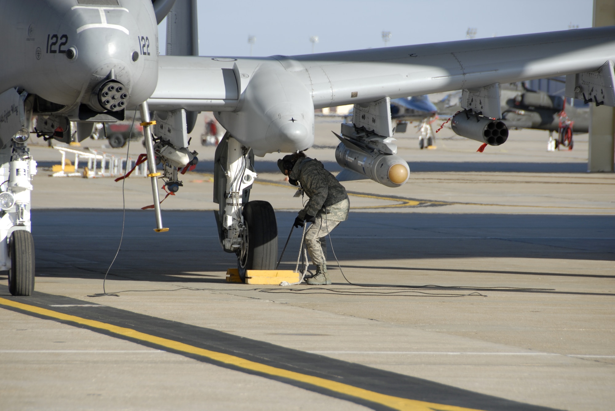Senior Airman Andrea Sumner pulls the wheel-chocks away from a 442nd Fighter Wing A-10 Thunderbolt II at Whiteman Air Force Base, Mo., Dec. 6, 2008, prior to the plane's launch on a training flight.  The 442nd is an Air Force Reserve Command unit, which operates, maintains and supports A-10 combat operations worldwide.  (U.S. Air Force photo/Staff Sgt. Tom Talbert) 