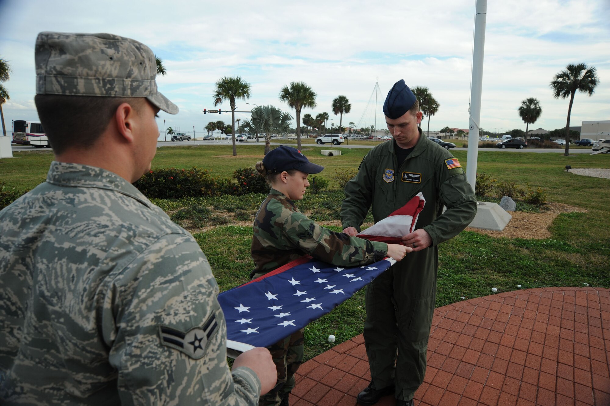 Airmen First Class Cole Woodworth, Airmen First Class Christina Estrada, 6th Operations Support Squadron, along with Senior Airmen Andy Reichard, 91st Air Refueling Squadron performs the flag folding portion of a Retreat ceremony Dec. 10 at the MacDill Memorial Park. When the flag is completely folded, only the blue field should be visible and it should be folded in the triangular shape of a cocked hat. The retreat ceremony serves a twofold purpose which is signaling the end of the official duty day and serves as a ceremony for paying respect to the United States flag. MacDill AFB instruction 36-2203 mandates the ceremony will be held every second Wednesday. This instruction applies to all 6th Air mobility wing subordinate units and staff agencies assigned to MacDill. The monthly retreat ceremony is an esprit de corps program to foster teamwork and pride in the 6 AMW and to publicly display our respect for the flag of the United States of America.  (U.S. Air Force photo by Staff Sgt. Ronnie Hill)