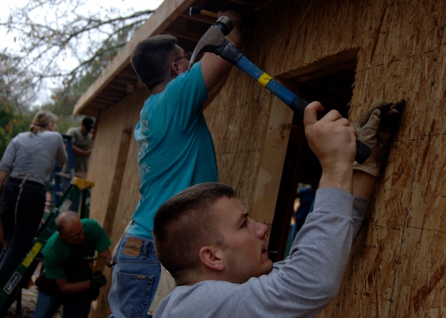 Airmen from Charleston AFB secure the siding to a house while volunteering for Habitat for Humanity off base Dec. 11. Organizations like the First Six and Top 3 sponsor many programs and initiatives like Habitat for Humanity to promote volunteering in local communities. (U.S. Air force photo/Senior Airman Timothy Taylor)

