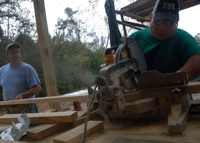 Robert Fackovec, left, and Ed Stephens, right, measure and cut wood with a table saw at a building site for Habitat for Humanity off base Dec. 11. Mr. Fackovec and Mr. Stephens, both from Charleston, S.C., volunteered to help build a house with Airmen from Team Charleston to help needy families. (U.S. Air force photo/Senior Airman Timothy Taylor)