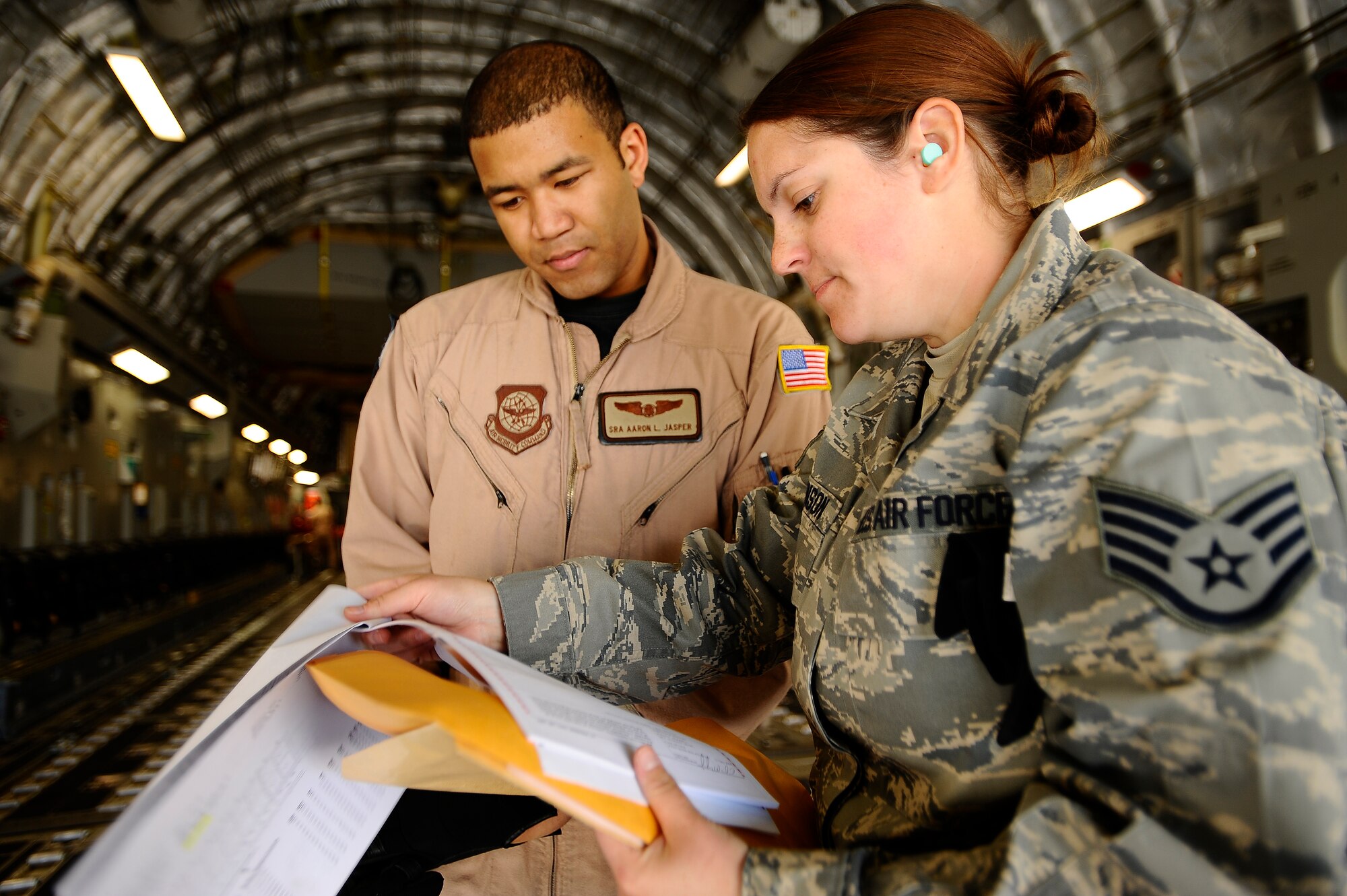 Staff Sgt. Kathleen Bronson (right) briefs Senior Airman Aaron Jasper about incoming cargo that will be loaded onto a C-17 Globemaster at Joint Base Balad, Iraq, Dec. 14. Bronson, a 332nd Expeditionary Logistics Readiness Squadron air transportation journeyman and native of Carbondale, Pa., is a reservist deployed from the 512th Airlift Wing, Dover Air Force Base, Del. Jasper is assigned to the 8th Airlift Squadron at McChord AFB, Wash. (U.S. Air Force photo/Airman 1st Class Jason Epley)