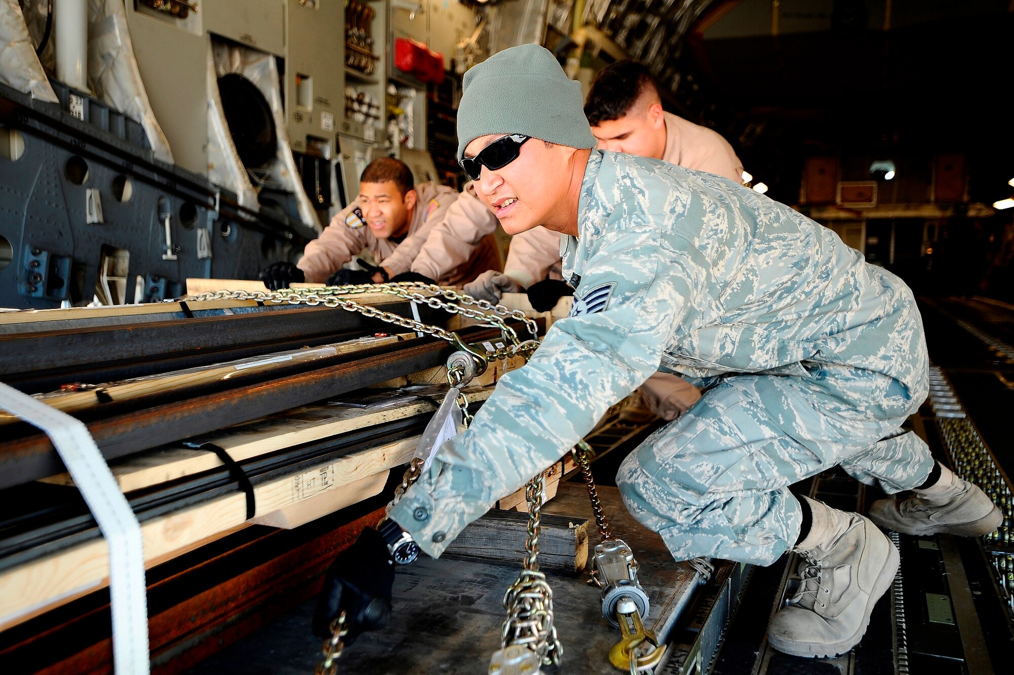 Staff Sgt. Zeus Lee pushes a palette of cargo from a C-17 Globemaster onto a 60K loader at Joint Base Balad, Iraq, Dec. 14. Lee, a 332nd Expeditionary Logistics Readiness Squadron load crew team chief and native of Jersey City, N.J., is deployed from the Air Force Reserve's 46th Aerial Port Squadron at Dover Air Force Base, Del. (U.S. Air Force photo/Airman 1st Class Jason Epley)
