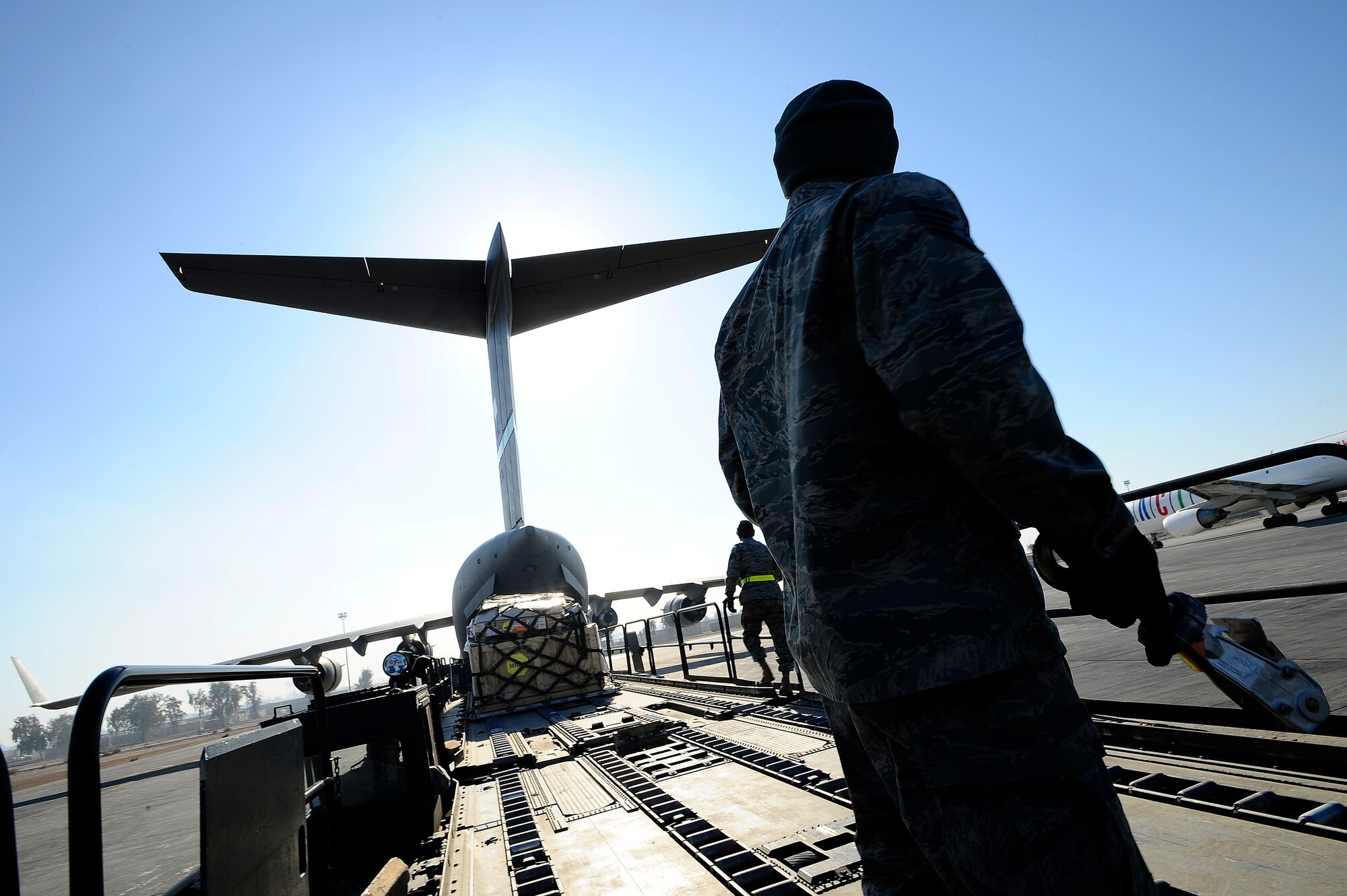 Staff Sgt. Zeus Lee watches a palette of cargo move from one 60K loader to another at Joint Base Balad, Iraq, Dec. 14. Several 60K loaders can be aligned, allowing cargo to move across until it reaches the aircraft. Lee, a 332nd Expeditionary Logistics Readiness Squadron load crew team chief and native of Jersey City, N.J., is deployed from the Air Force Reserve's 46th Aerial Port Squadron, Dover Air Force Base, Del. (U.S. Air Force photo/Airman 1st Class Jason Epley)