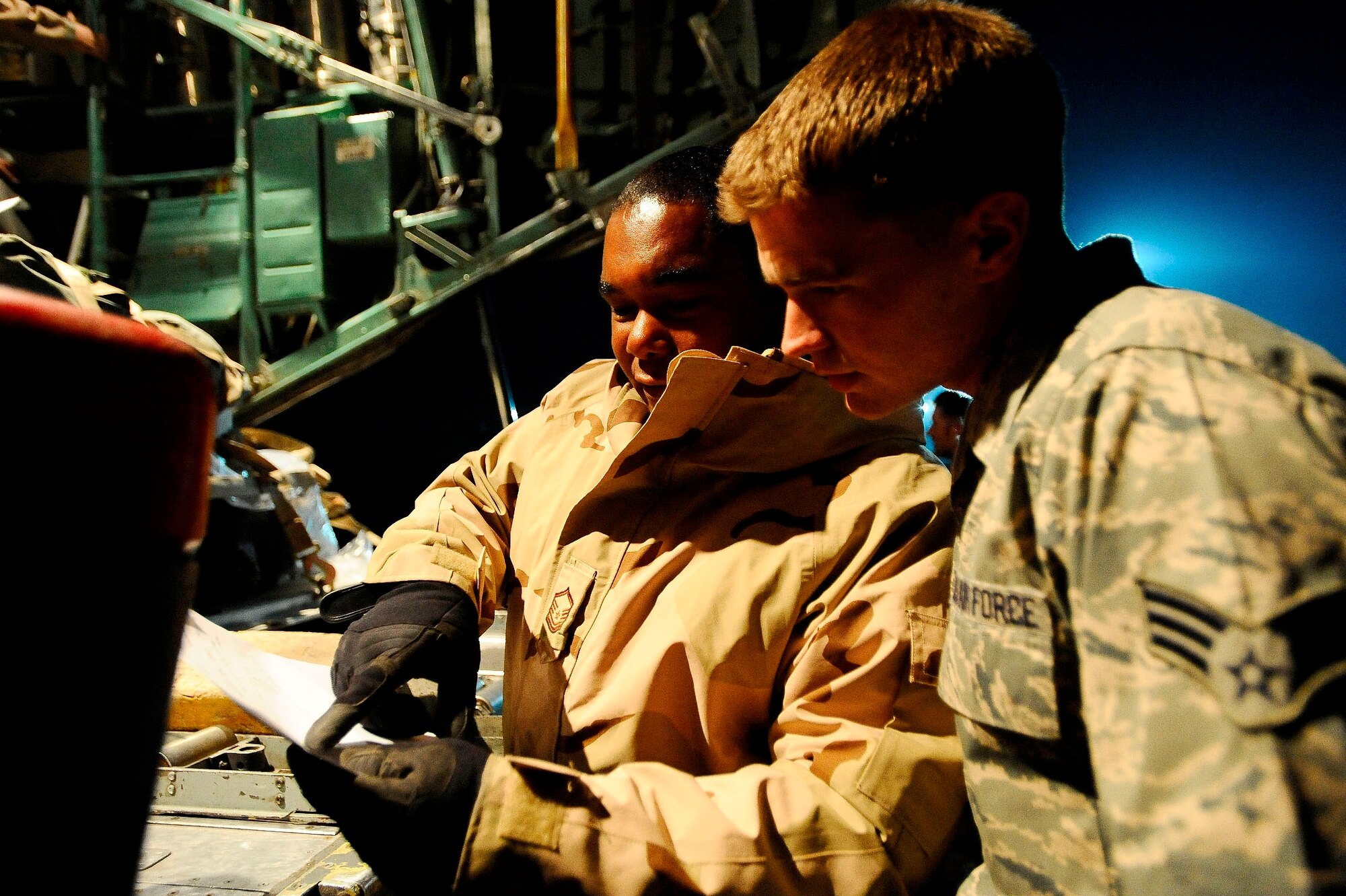Master Sgt. Chuck Knight and Senior Airman Coban Goertz look over a receipt from registered mail that they delivered to a C-130 Hercules at Joint Base Balad, Iraq, Dec. 13. Knight, the 332nd Expeditionary Logistics Readiness Squadron day shift NCO in charge of special cargo and a native of Natchez, Miss., is deployed from Dover Air Force Base, Del. Goertz, a 332nd ELRS aerial porter ramp specialist and native of Dover, Del., is deployed from Dover AFB. The reservists are assigned to the 512th Airlift Wing's 46th Aerial Port Squadron. (U.S. Air Force photo/Airman 1st Class Jason Epley)