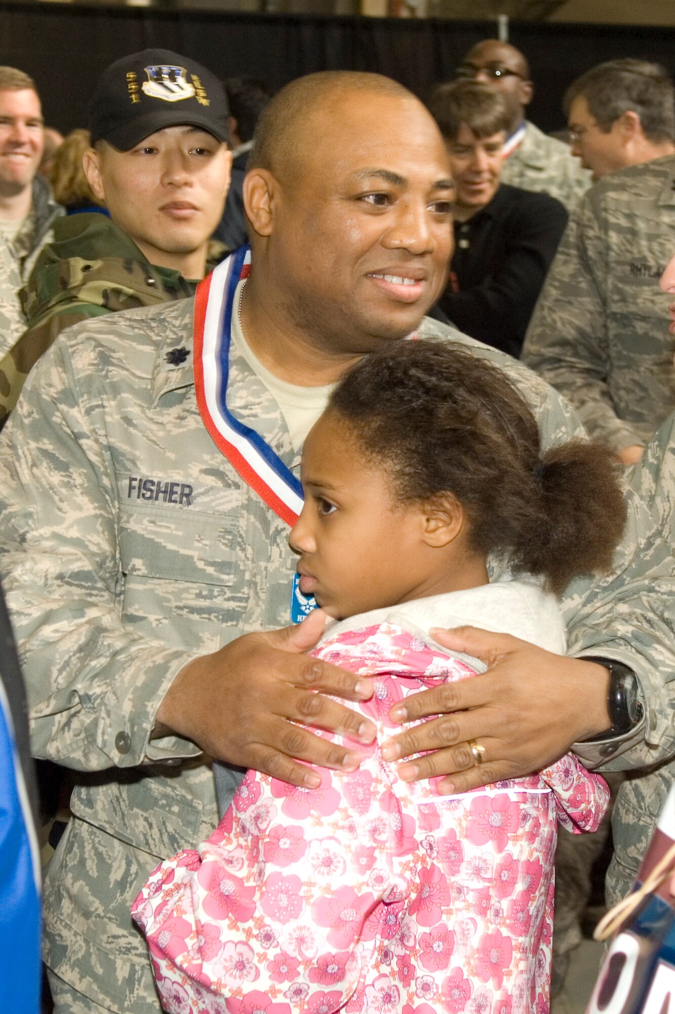 HANSCOM AIR FORCE BASE, Mass. – Lt. Col. Tyron Fisher, 632nd Electronic Systems Squadron commander, hugs his daughter Tyra, during the Heroes’ Homecoming celebration that took place Dec. 12. The event officially welcomed home all of Hanscom’s Airmen that have served on deployments over the past six months. Colonel Fisher returned from his deployment to Iraq just an hour before the start of the ceremony. (U.S. Air Force photo by Rick Berry)