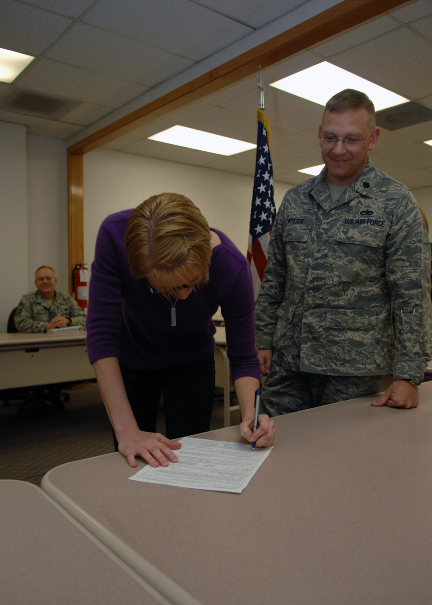 Airman 1st Class Terri Cowan signs the oath of enlistment for the 301st Fighter Wing, Detachment 1, during the re-enlistment ceremony at Holloman Air Force Base, N.M., Dec. 3. After serving active duty, Airman Cowan joins the reserves for three years into the 2A674 Fuels Systems slot. (U.S. Air Force photo/Airman 1st Class Veronica Salgado)