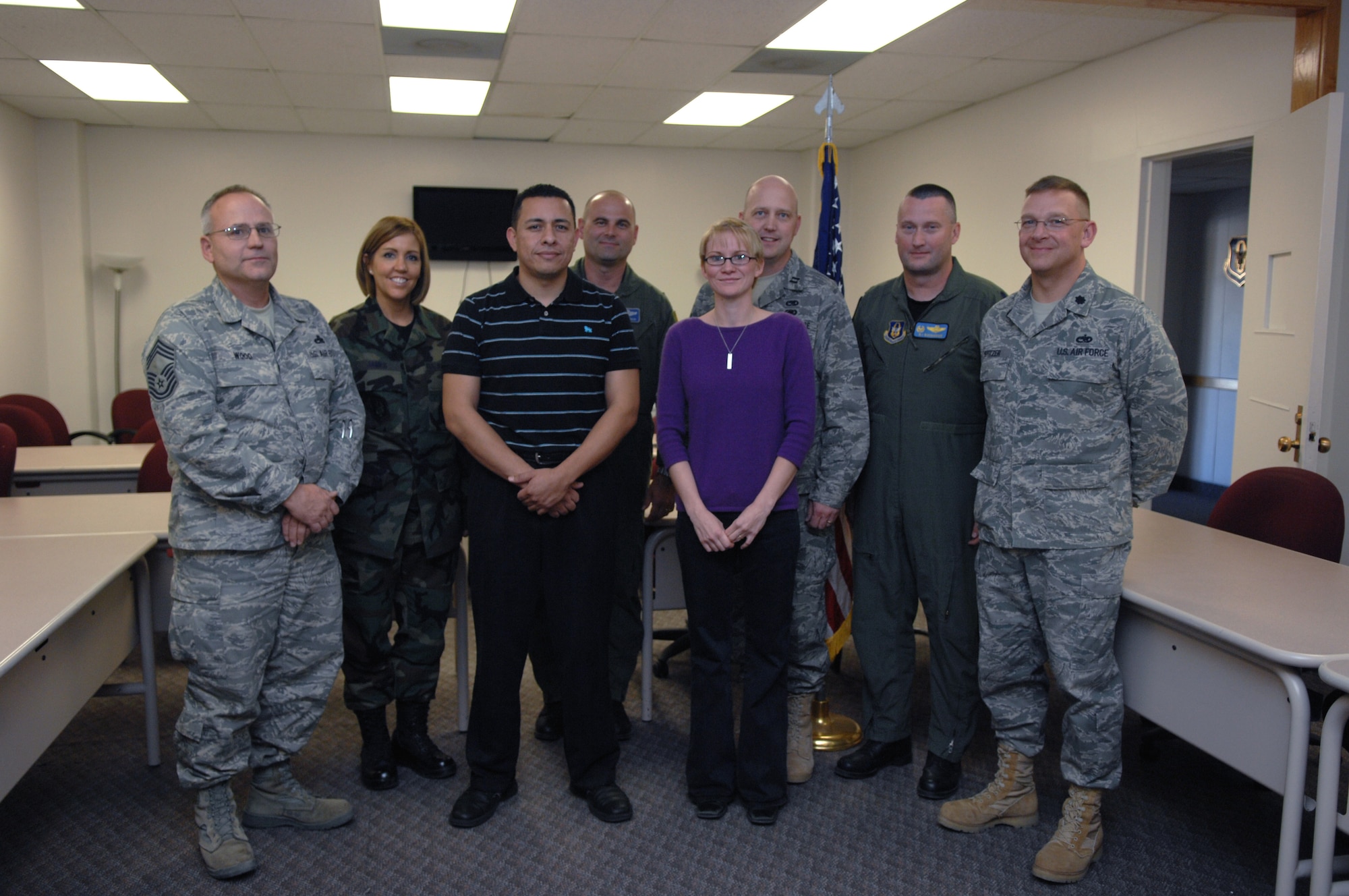 Senior Airman Jay Tarango and Airman 1st Class Terri Cowan pose for a group photo with members of the 301st Fighter Wing, Detachment 1, during their re-enlistment ceremony into the Air Force Reserves at Holloman Air Force Base, N.M., Dec. 3. The two Airmen are the first two full enlistments to join the 301st Fighter Wing. (U.S. Air Force photo/Airman 1st Class Veronica Salgado)