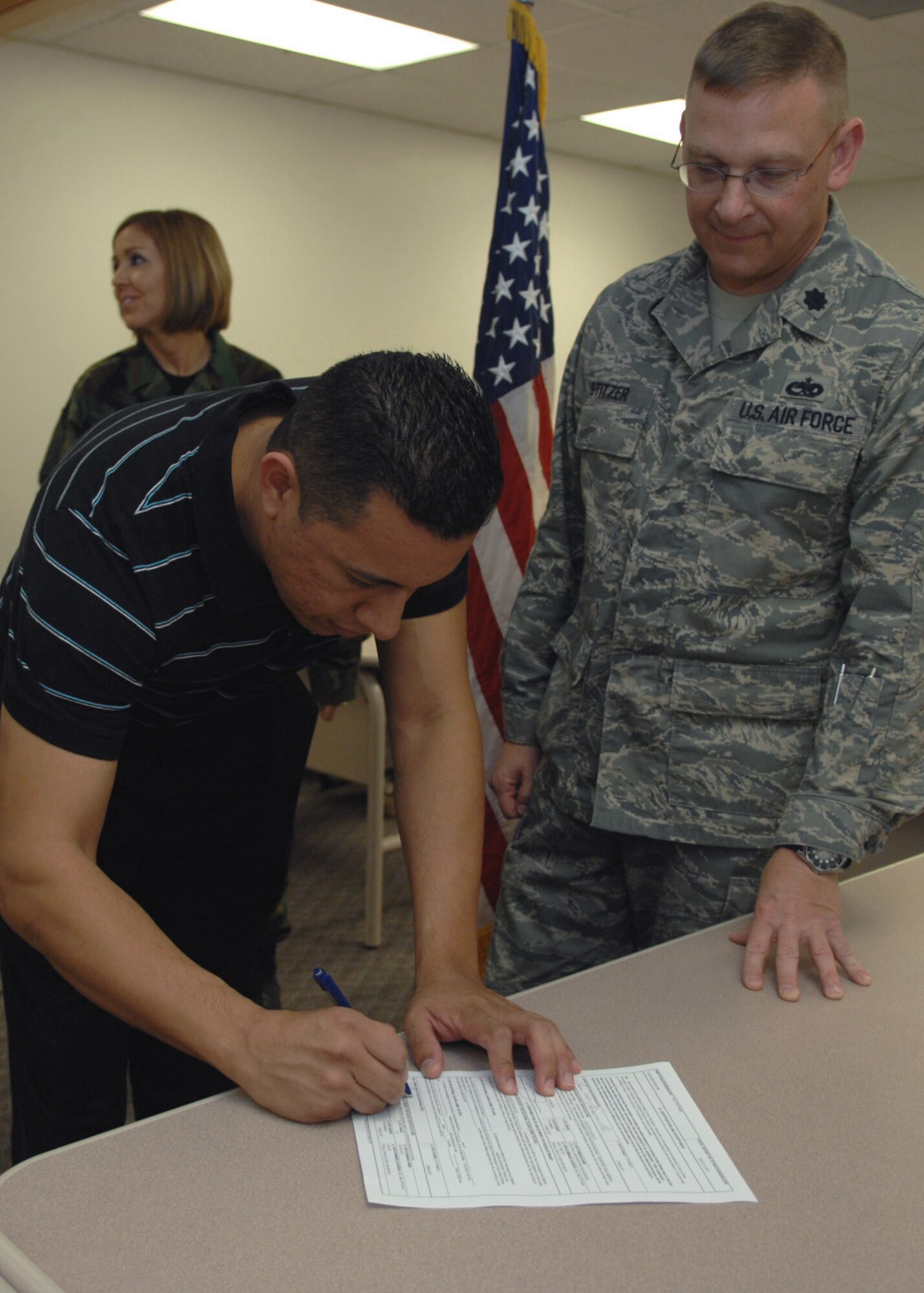 Senior Airman Jay Tarango Jr. signs the oath of enlistment into the 301st Fighter Wing, Detachment 1, during the re-enlistment ceremony at Holloman Air Force Base, N.M., Dec. 3. After four years of active duty in 1998, Airman Tarango re-enlists to be a part of the Aircraft Structural Maintenance reserves for six years. (U.S. Air Force photo/Airman 1st Class Veronica Salgado)