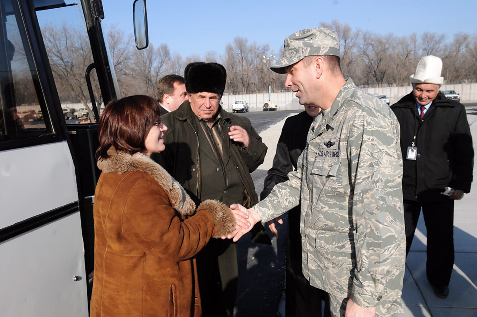 Col. Christopher Bence greets Magiyat Abakirova as leaders from Kyrgyz villages arrive for a Dec. 10 tour of Manas Air Base, Kyrgyzstan. Leaders from six villages around Manas AB visited the base and had lunch with wing leaders. The visit strengthened friendships and issues affecting the local villages that the base can assist with were discussed. Colonel Bence is the 376th Air Expeditionary Wing commander. Ms. Abakirova is the chief accountant for Jany Pakhta village. (U.S. Air Force photo/Senior Airman Ruth Holcomb) 
