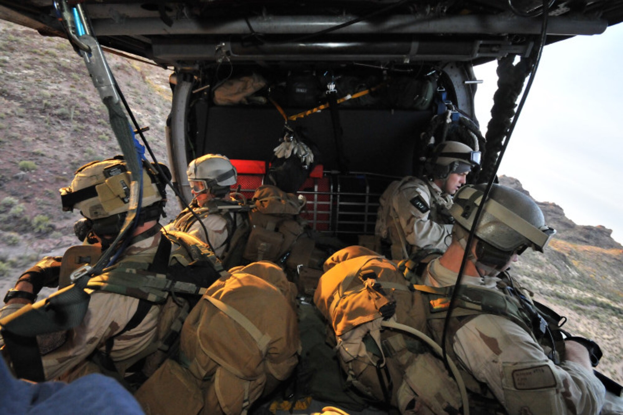 Pararescuemen from the 48th Rescue Squadron out of Davis- Monthan Air Force Base, Ariz., fly aboard an HH-60 from the 129th Rescue Wing out of Moffett Federal Airfield, Calif., during a rescue scenario.  The exercise took place at Davis-Monthan from Dec. 1-12.  Angel Thunder is the largest personnel recovery exercise in the world designed to train a joint, interagency and international audience in effectively executing the personnel recovery mission. (photo by Greg Morehead).


