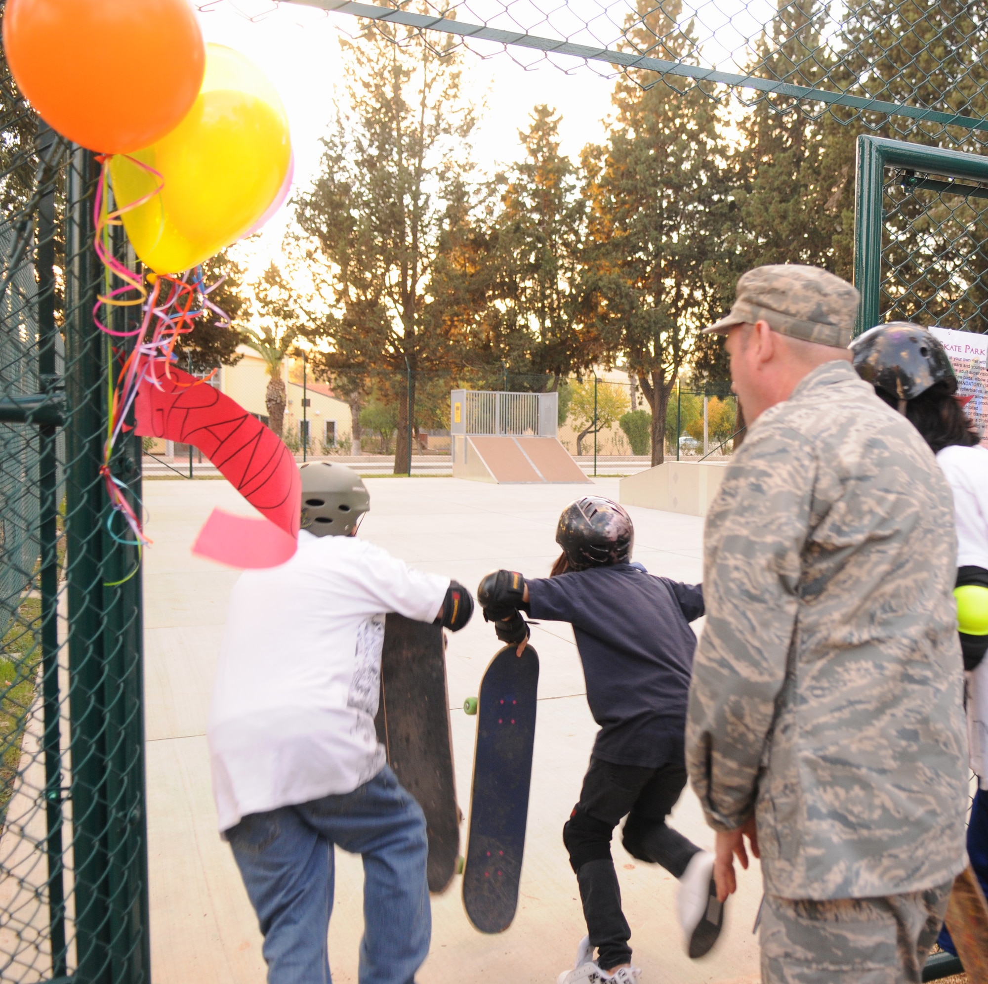 Colonel Andrew Pears, 39th Mission Support Group commander, stands back after cutting the ceremonial banner for the youth center’s new skate park, as two youth center teens run in Dec. 12. (Air Force photo by Airman 1st class Amber Russell)