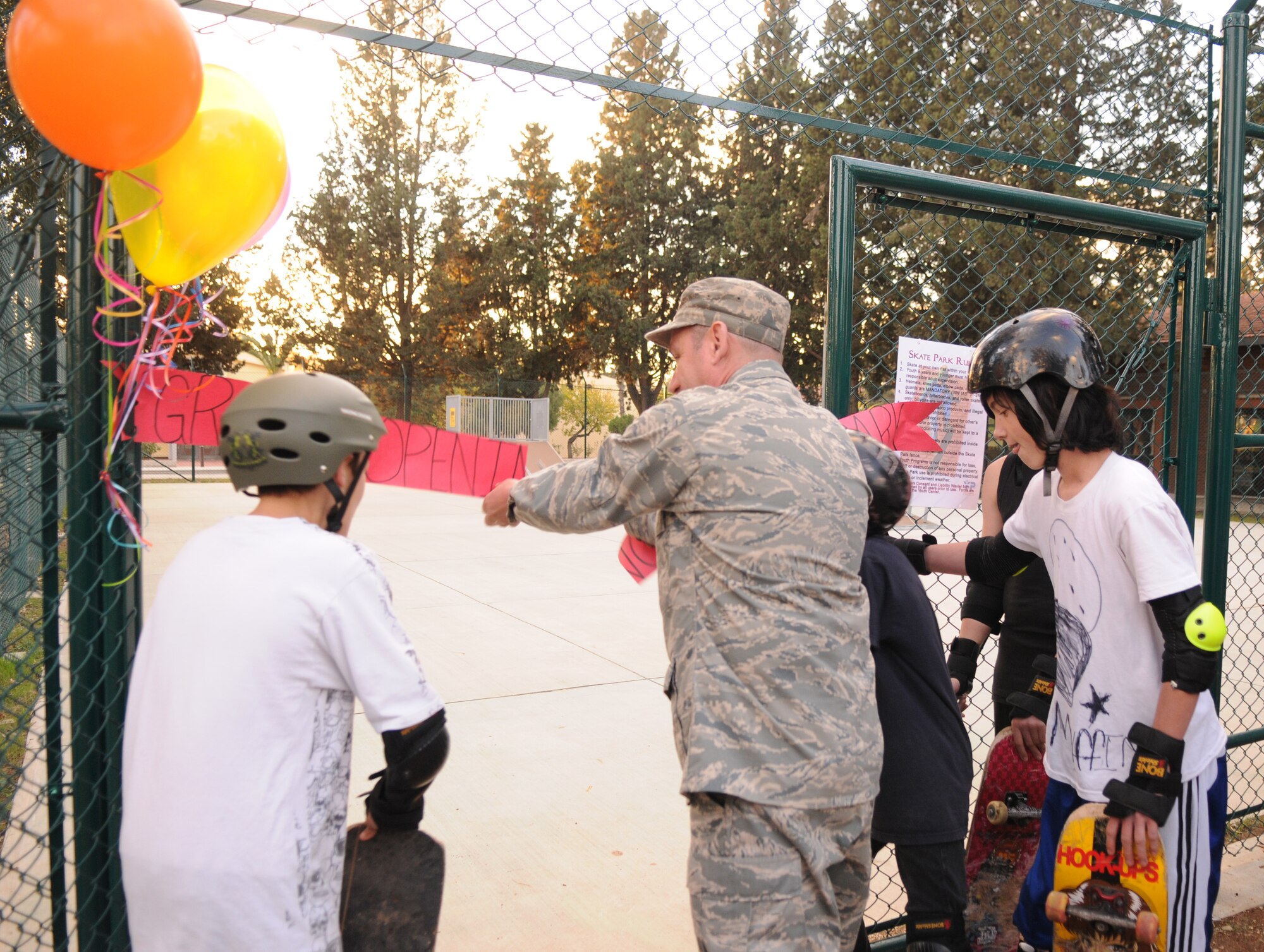Colonel Andrew Pears, 39th Mission Support Group commander, clips the banner for the grand opening of the Youth Centers’ new skate park Dec. 12, as teenagers from the youth center wait excitedly. (Air Force photo by Airman 1st class Amber Russell)