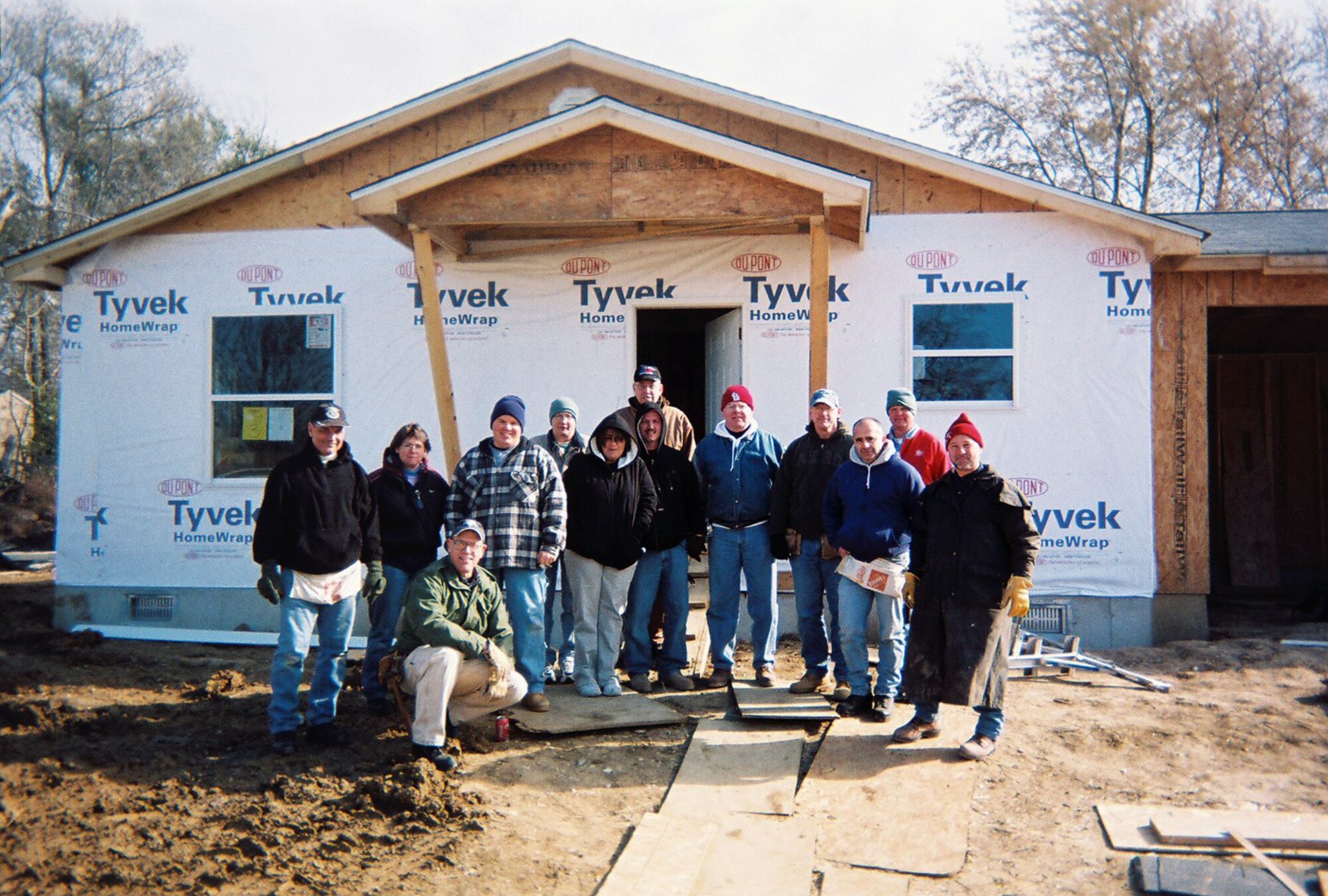 Col. Robert Leeker, Senior Master Sgt. Vicki Rolape, (Ret) Chief Master Sgt. David Brown, Master Sgt. Rick Champ, Senior Master Sgt. Angie Varvel, Jennifer Wilson, Senior Master Sgt. Robert Wilson, Master Sgt. Bernie Botson, Senior Master Sgt. John Morrisay, Senior Master Sgt. Ron Chostner, Master Sgt. Fernando Martins, Senior Master Sgt. Dennis Rauss, Chief Master Sgt. Earl Rolape gather around the home they volunteered their time to help build with Habitat for Humanity Nov. 22.  This is the fourth time NCOAGA Chapter 14 has worked with Habitat for Humanity. (Courtesy Photo) 