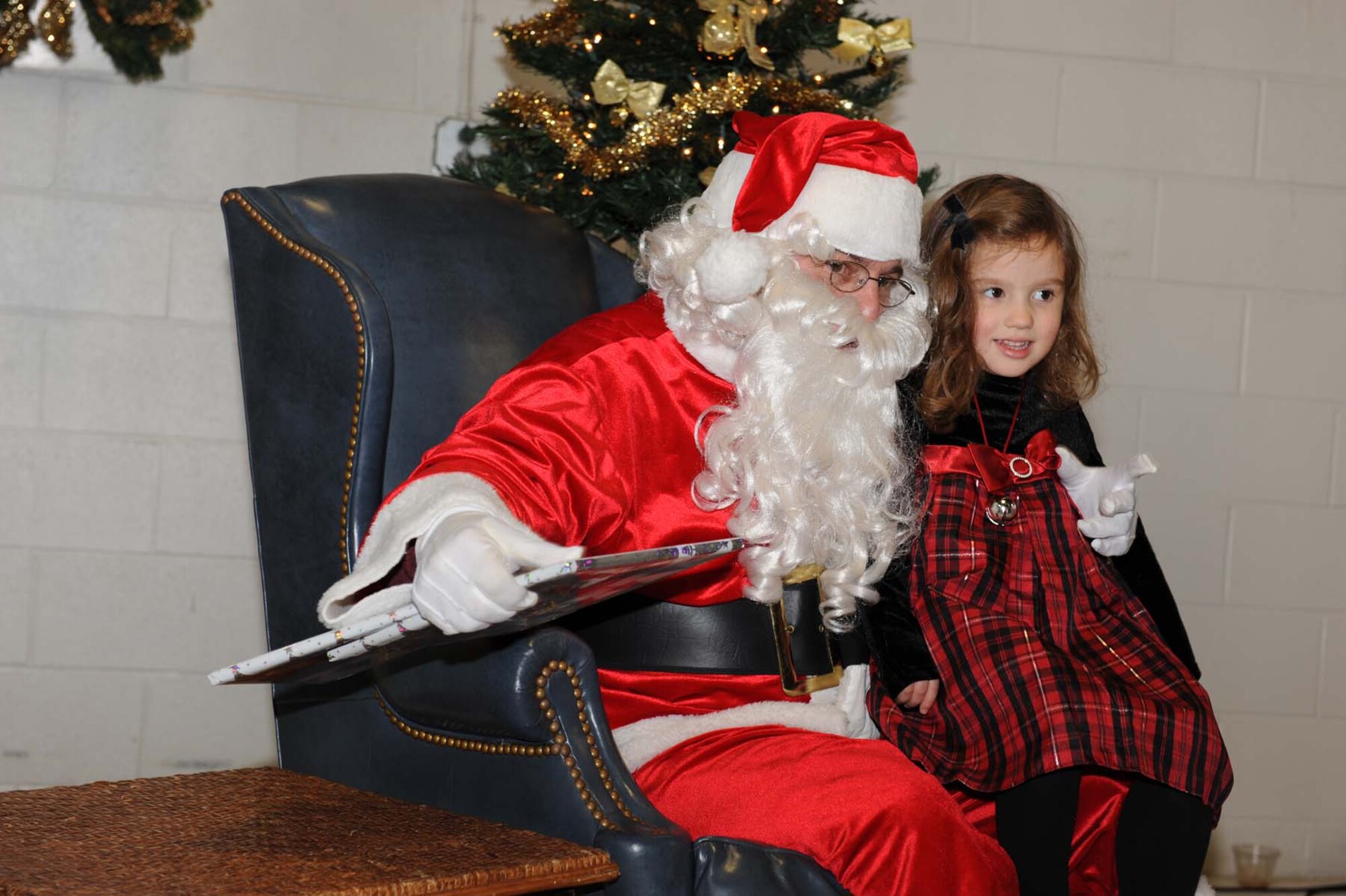 SHAW AIR FORCE BASE, S.C -- Santa a.k.a. Rick Hines, 20th Operations Group honorary commander, gives 55th Fighter Squadron pilot Captain Bill Maclin's daughter Kaitlyn presents from the 20th OG Dec. 14. Mr. Hines arrived by F-16 during the 20th OG Christmas party to give presents to the children. (U.S. Air Force photo/Senior Airman Matthew Davis)