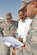SOUTHWEST ASIA -- Staff Sgts. Arturo Castro (left) and Jamie Lugo (right) discuss plans with a contractor while third-country nationals begin the initial stages of construction on a liquid- and gas-oxygen storage facility here Dec. 14. Sergeant Castro is a contracting technician from the 380th Expeditionary Contracting Squadron and Sergeant Lugo is from the 380th Expeditionary Civil Engineer Squadron. (US Air Force photo by Tech. Sgt. Denise Johnson) (released)