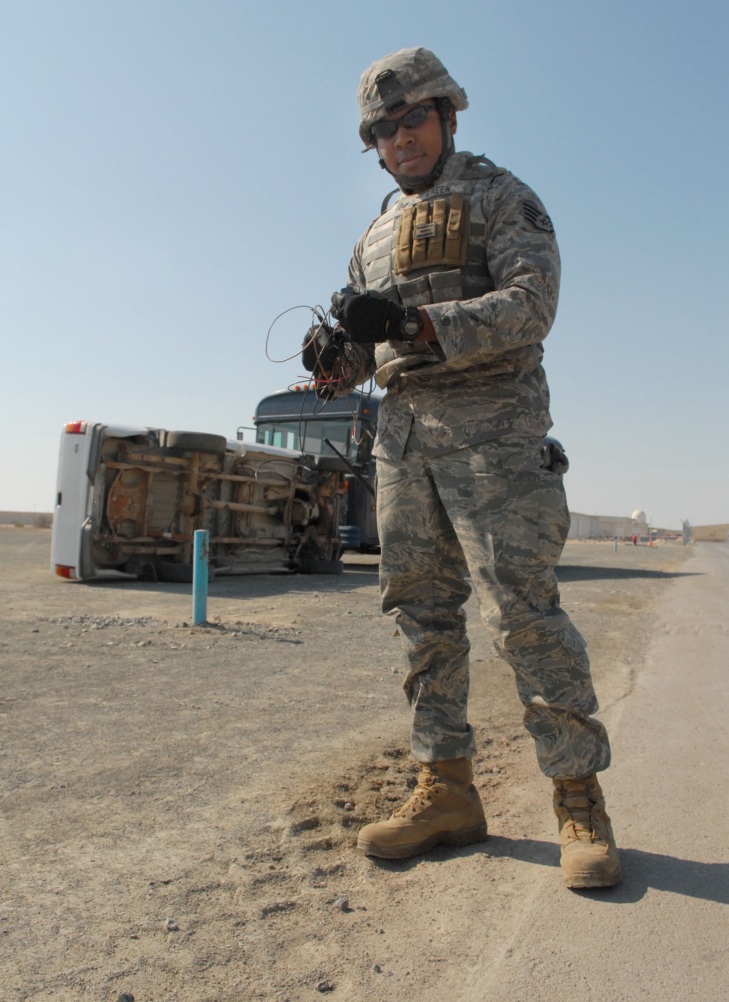 SOUTHWEST ASIA -- Staff Sgt. Keith Green, 380th Expeditionary Civil Engineer Explosive Ordnance Flight technician, collects pieces of a simulated Improvised Explosive Device after a simulated terrorist attack here Dec. 12. The deployed Airmen are all part of an exercise which tests and evaluates the 380th Air Expeditionary Wing's response to real-world scenarios. (US Air Force photo by Tech. Sgt. Denise Johnson) (released)