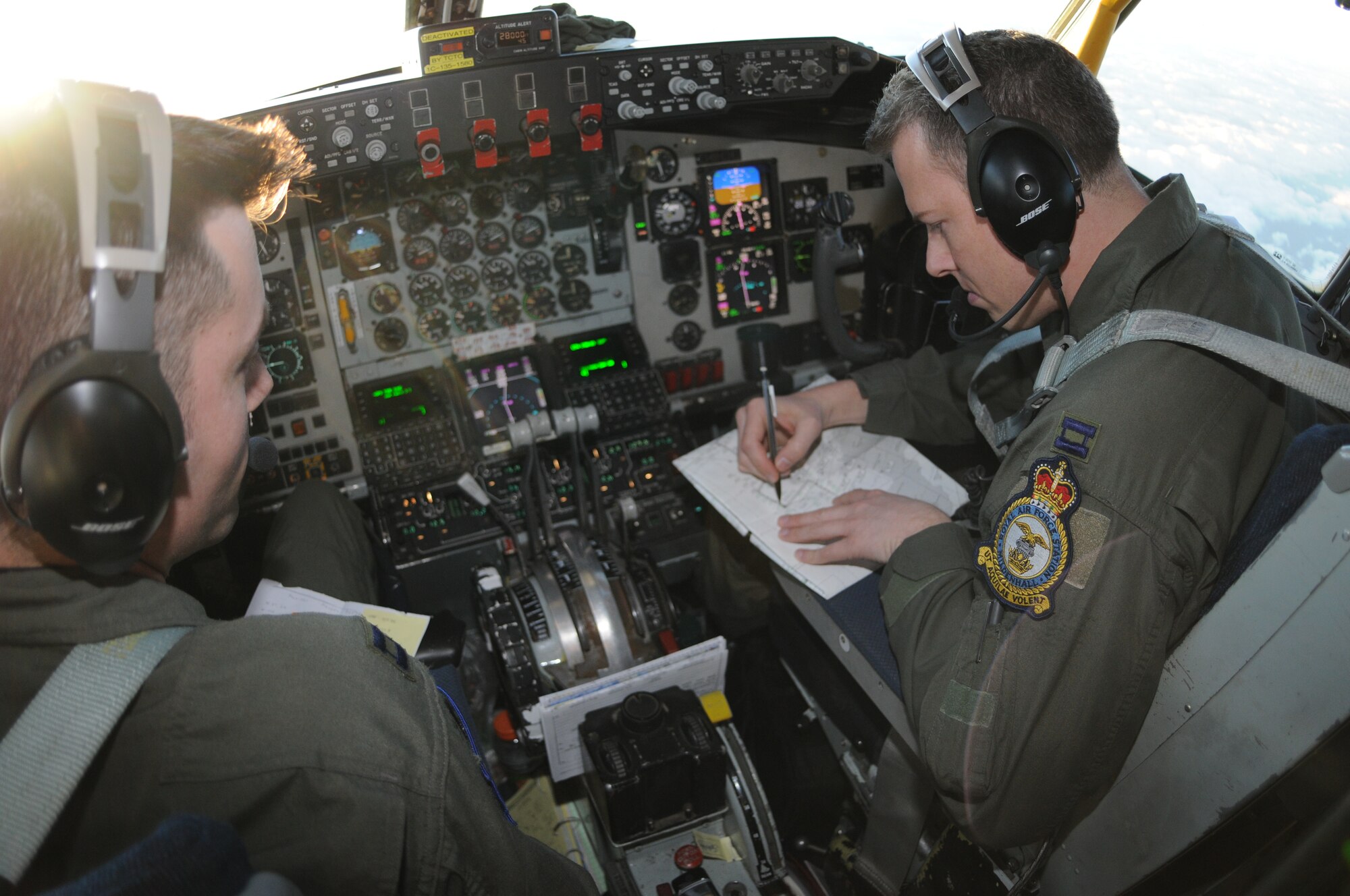 Capt. Chris Saettel, 351st Air Refueling Squadron aircraft commander, discusses oceanic clearance with his co-pilot, Capt. Josh Renfro while enroute to refuel a MC-130 Hercules cargo plane. The aircraft were traveling to a rescue mission involving a critically injured crewman on a cargo vessel off the coast of Ireland. The patient had critical head trauma from a fall on the ship. His injuries were considered life threatening. (U.S. Air Force Photo by Master Sgt. Charles Tubbs)