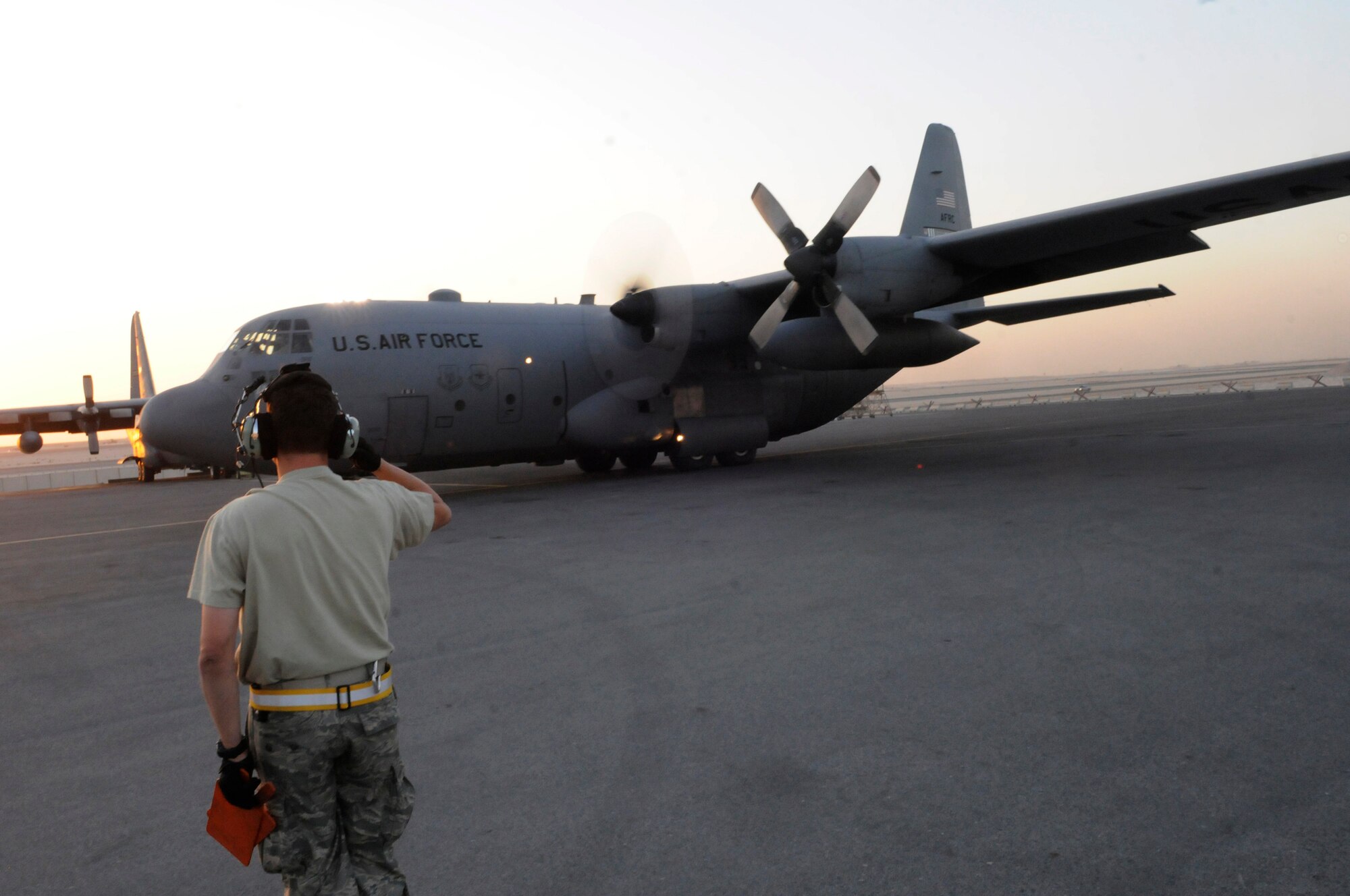 Tech. Sgt. Abner Berrios, a crew chief assigned to the 379th Expeditionary Aircraft Maintenance Squadron, salutes the pilot of a C-130 Hercules as it taxies away, Dec. 13, at an undisclosed air base in southwest Asia.  The C-130 primarily performs the tactical portion of the airlift mission. The aircraft is capable of operating from rough, dirt strips and is the prime transport for air dropping troops and equipment into hostile areas in the Central Command area of responsibility.  Sergeant Berrios, a native of San Juan, Puerto Rico, is deployed from Pope Air Force Base, N.C., in support of Operations Iraqi and Enduring Freedom and Joint Task Force-Horn of Africa.  (U.S. Air Force photo by Tech. Sgt. Michael Boquette/Released)