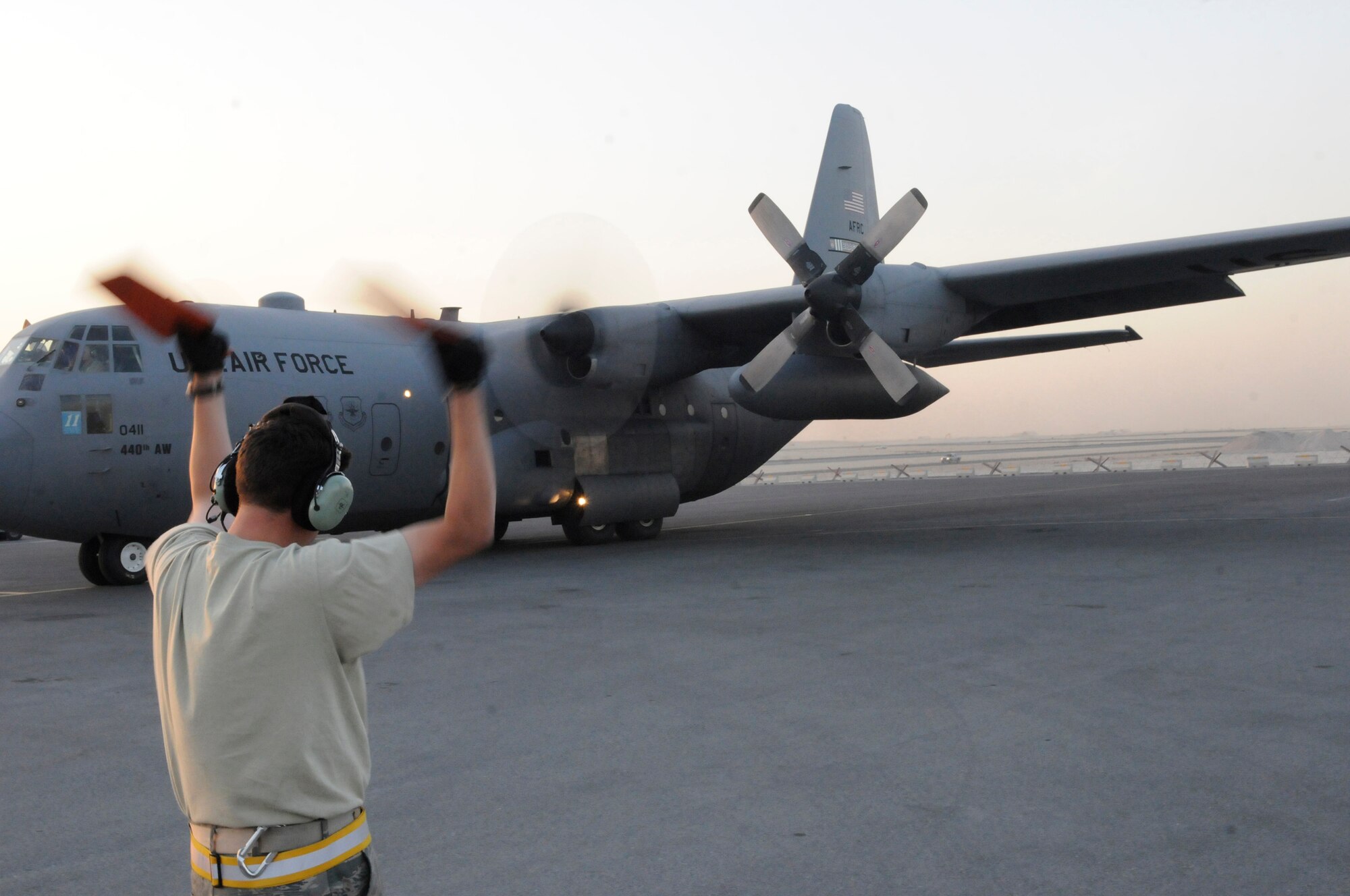 Tech. Sgt. Abner Berrios, a crew chief assigned to the 379th Expeditionary Aircraft Maintenance Squadron, marshals a C-130 Hercules as it taxies from its parking area, Dec. 13, at an undisclosed air base in southwest Asia.  The C-130 primarily performs the tactical portion of the airlift mission. The aircraft is capable of operating from rough, dirt strips and is the prime transport for air dropping troops and equipment into hostile areas in the Central Command area of responsibility.  Sergeant Berrios, a native of San Juan, Puerto Rico, is deployed from Pope Air Force Base, N.C., in support of Operations Iraqi and Enduring Freedom and Joint Task Force-Horn of Africa.  (U.S. Air Force photo by Tech. Sgt. Michael Boquette/Released)