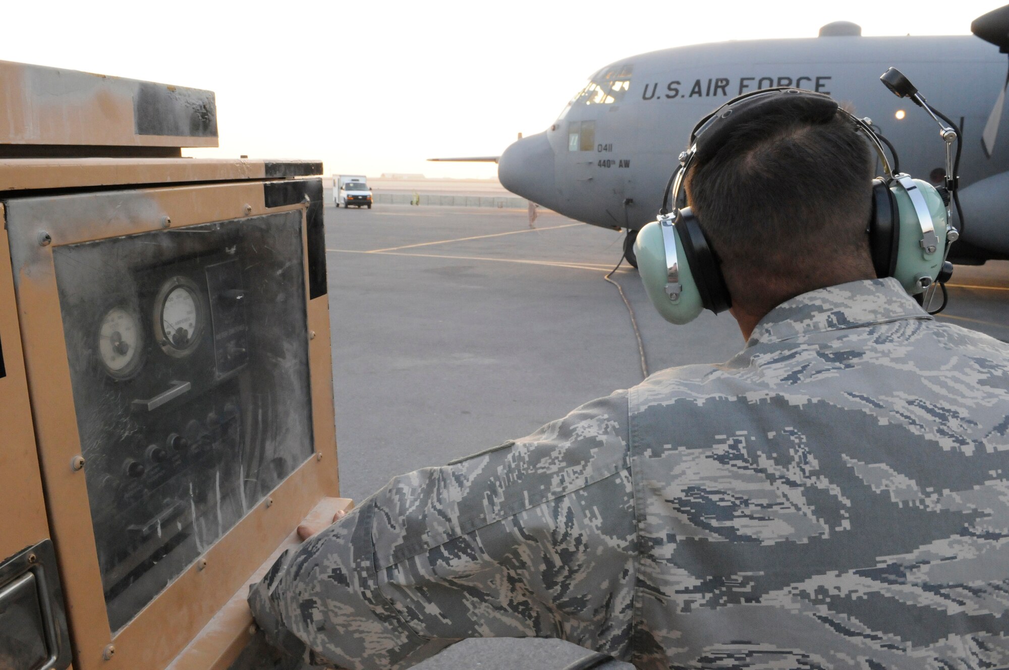 Tech. Sgt. Franco Russo, a crew chief assigned to the 379th Expeditionary Aircraft Maintenance Squadron, holds position at a power cart during engine start up on a C-130 Hercules, Dec. 13, at an undisclosed air base in Southwest Asia.  The C-130 primarily performs the tactical portion of the airlift mission. The aircraft is capable of operating from rough, dirt strips and is the prime transport for air dropping troops and equipment into hostile areas in the Central Command area of responsibility.  Sergeant Russo, a native of Cleveland, Ohio, is deployed from Pope Air Force Base, N.C., in support of Operations Iraqi and Enduring Freedom and Joint Task Force-Horn of Africa.  (U.S. Air Force photo by Tech. Sgt. Michael Boquette/Released)