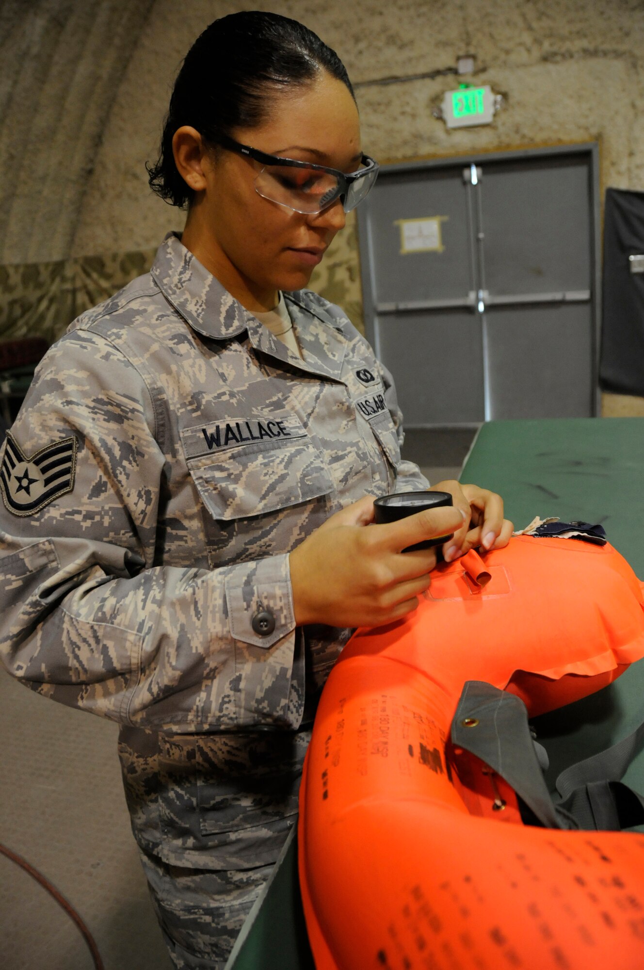 Staff Sergeant Alexis Wallace, aircrew flight equipment technician assigned to the 379th Expeditionary Operations Support Squadron, uses an air pressure gauge to ensure the right amount of pressure is inside a life preserver as part of a leak test Dec. 14, at an undisclosed air base in Southwest Asia. These EOSS members are responsible for ensuring pilots have proper and operational equipment in case of an emergency evacuation. Sergeant Wallace, a native of Fayetteville, N.C., is deployed from Pope Air Force Base, N.C., in support of Operations Iraqi and Enduring Freedom and Joint Task Force-Horn of Africa. (U.S. Air Force photo by Staff Sgt. Darnell T. Cannady/Released)