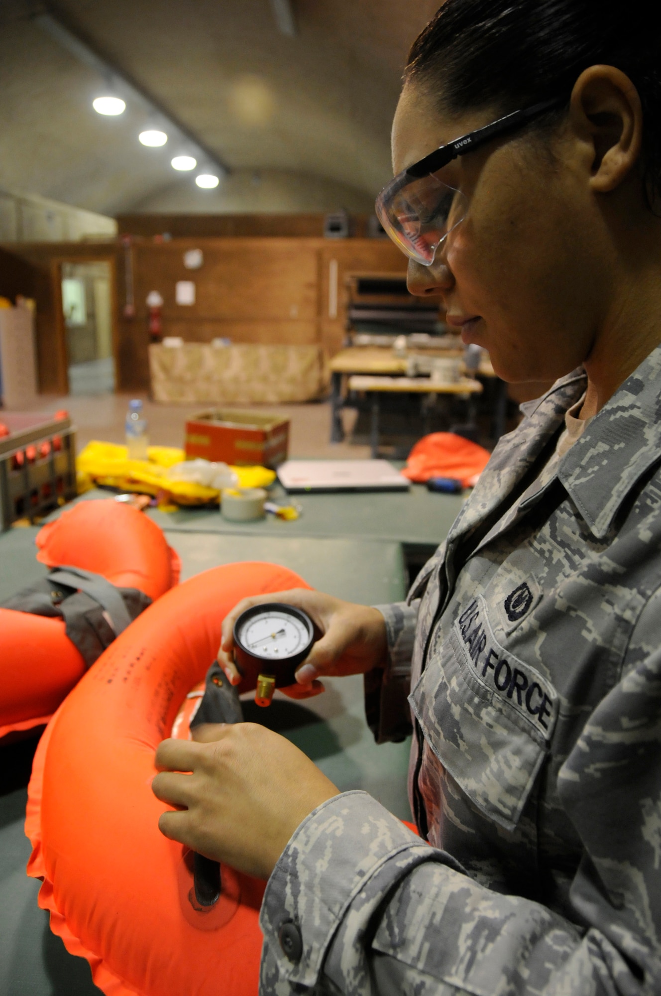Staff Sergeant Alexis Wallace, aircrew flight equipment technician assigned to the 379th Expeditionary Operations Support Squadron, uses an air pressure gauge to ensure the right amount of pressure is inside a life preserver as part of a leak test Dec. 14, at an undisclosed air base in Southwest Asia. These EOSS members are responsible for ensuring pilots have proper and operational equipment in case of an emergency evacuation. Sergeant Wallace, a native of Fayetteville, N.C., is deployed from Pope Air Force Base, N.C., in support of Operations Iraqi and Enduring Freedom and Joint Task Force-Horn of Africa. (U.S. Air Force photo by Staff Sgt. Darnell T. Cannady/Released)