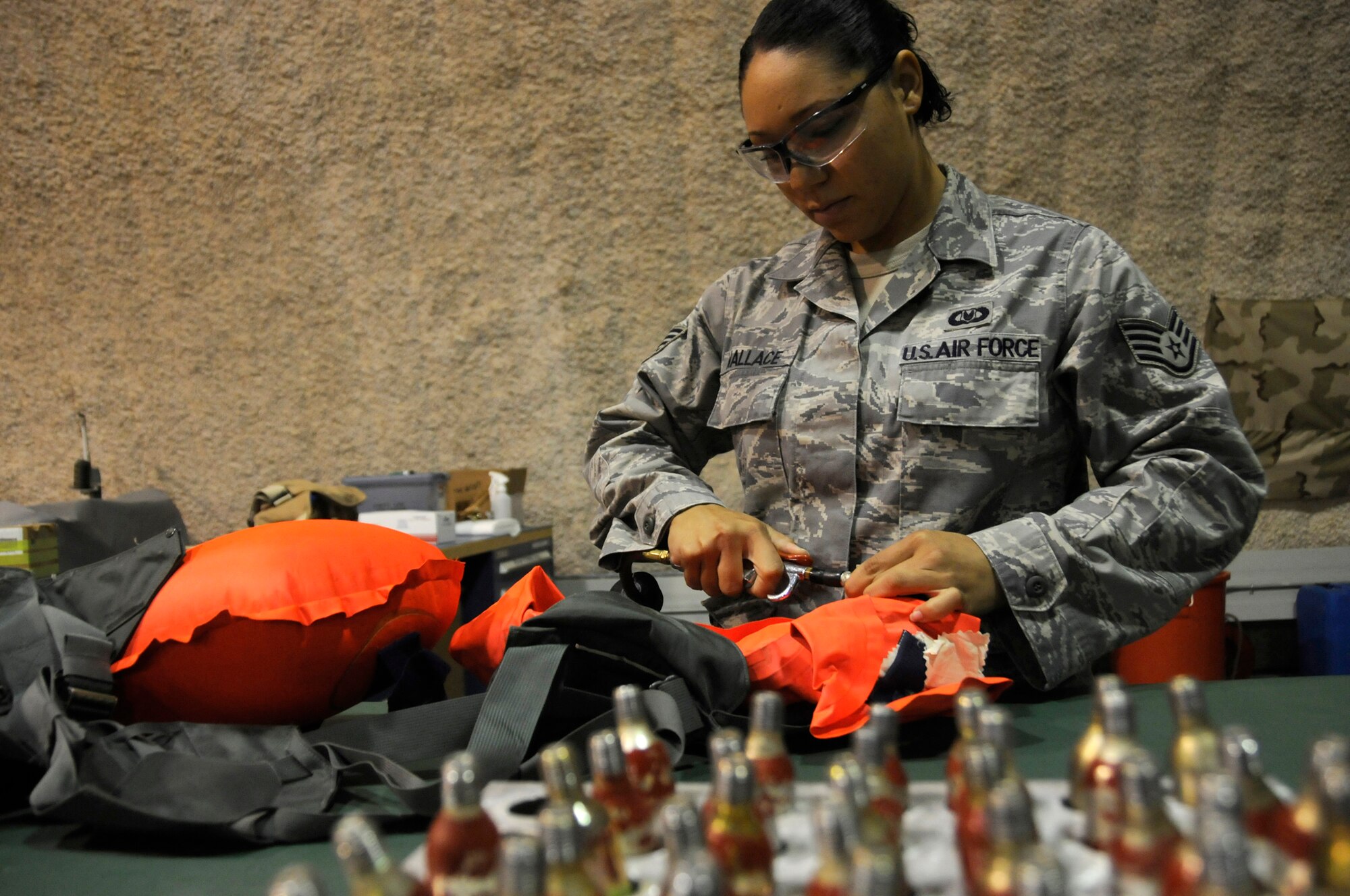 Staff Sergeant Alexis Wallace, aircrew flight equipment technician assigned to the 379th Expeditionary Operations Support Squadron, inflates a life preserver unit 10/P using an air hose as part of a leak test Dec. 14, at an undisclosed air base in Southwest Asia. These EOSS members are responsible for ensuring pilots have proper and operational equipment in case of an emergency evacuation. Sergeant Wallace, a native of Fayetteville, N.C., is deployed from Pope Air Force Base, N.C., in support of Operations Iraqi and Enduring Freedom and Joint Task Force-Horn of Africa. (U.S. Air Force photo by Staff Sgt. Darnell T. Cannady/Released)