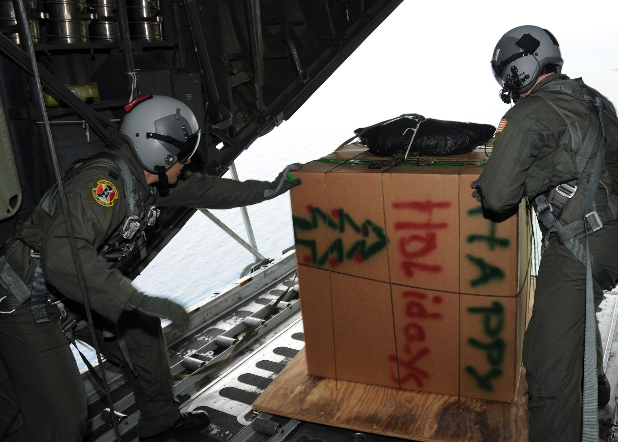 ANDERSEN AIR FORCE BASE, Guam - Capt. John Fuccillo and Staff Sgt. Ian Hunt, both from the 36th Airlift Squadron, Yokota, Japan, push a box Dec. 14 filled with supplies destined for a remote island near Chuuk during the first mission for Operation Christmas Drop.  The delivery was the first of more than 180 boxes dropped to islands in the Commonwealth of the Northern Marianas Islands, Yap, Palau, Chuuk and Pohnpei. Through military and local community support, OCD has collected tens of thousands of donated items and raised more than $30,000 in support of the operation. (U.S. Air Force photo by Staff Sgt Jamie Lessard)