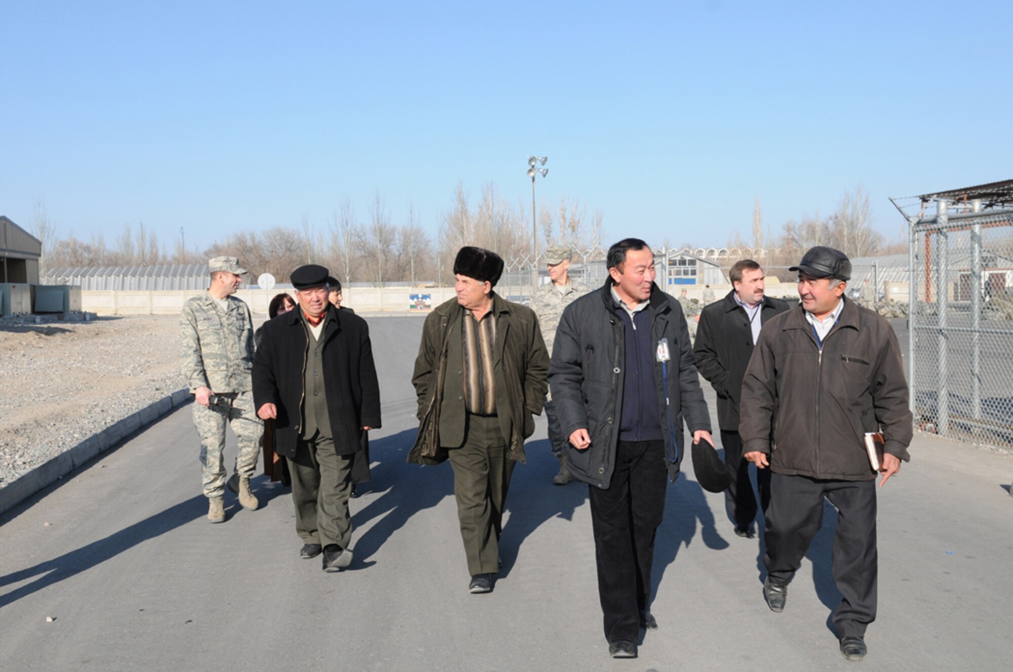 Col. Christopher Bence, 376th Air Expeditionary Wing commander, talks with local Kyrgyz village mayors and their deputies as he leads them on a tour of Manas AB, Dec. 10. Leadership from six villages around Manas visited the base and had lunch with wing leadership, Dec. 10. The visit provided an opportunity to strengthen friendships and discuss issues affecting the local villages that the base can assist with. (Air Force photo / Senior Airman Ruth Holcomb) 	