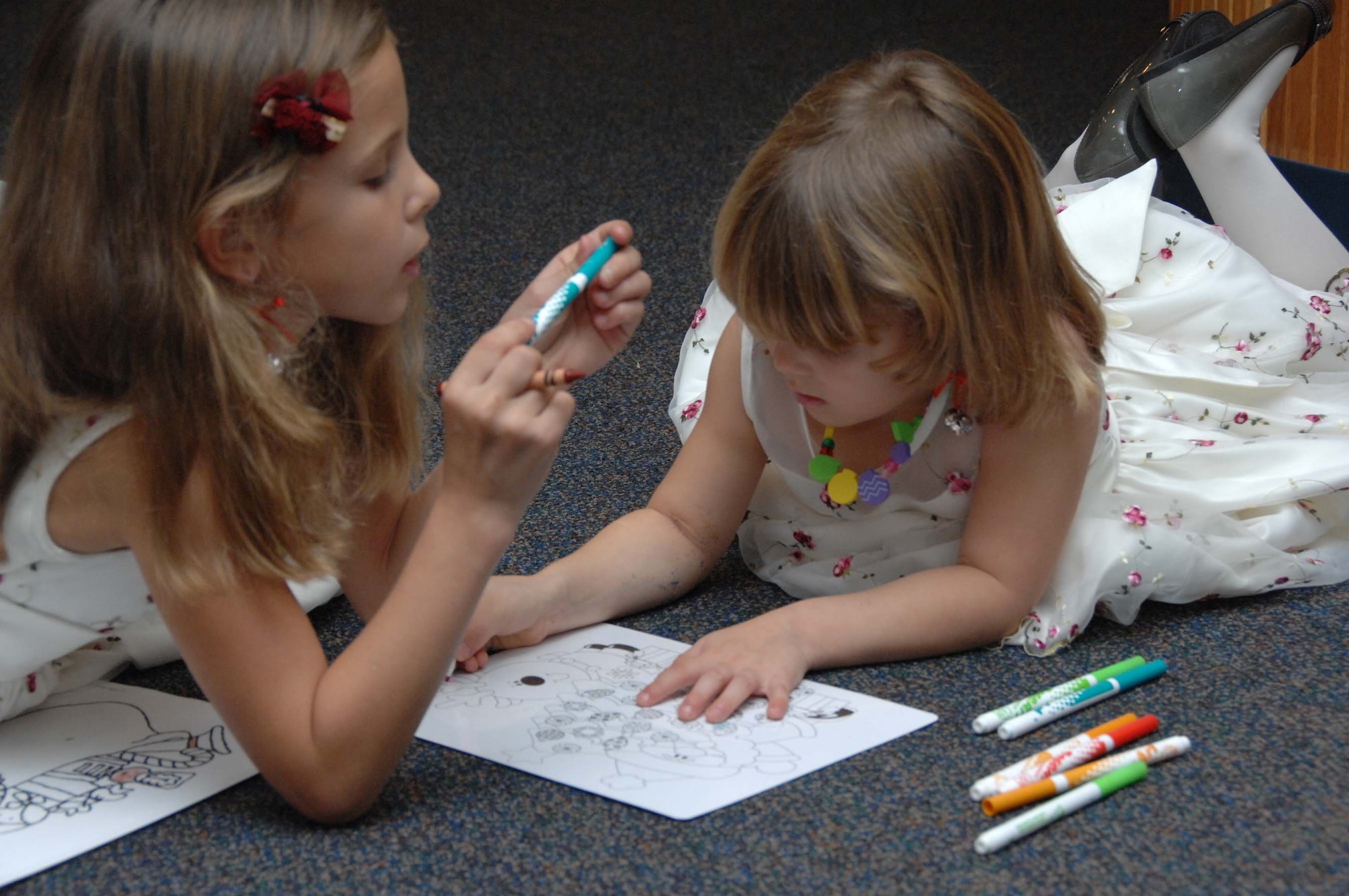 SHAW AIR FORCE BASE, S.C. -- Katelynn and Daniella find a comfortable spot on the floor of the Airmen and Family Readiness Center to color at the Hearts Apart Children's Christmas party Thursday, Dec. 11. "My husband is in Iraq," said their mother, Laura Thorpe. "He should be home hopefully in 30 days." (U.S. Air Force photo/2nd Lt. Emily Chilson)