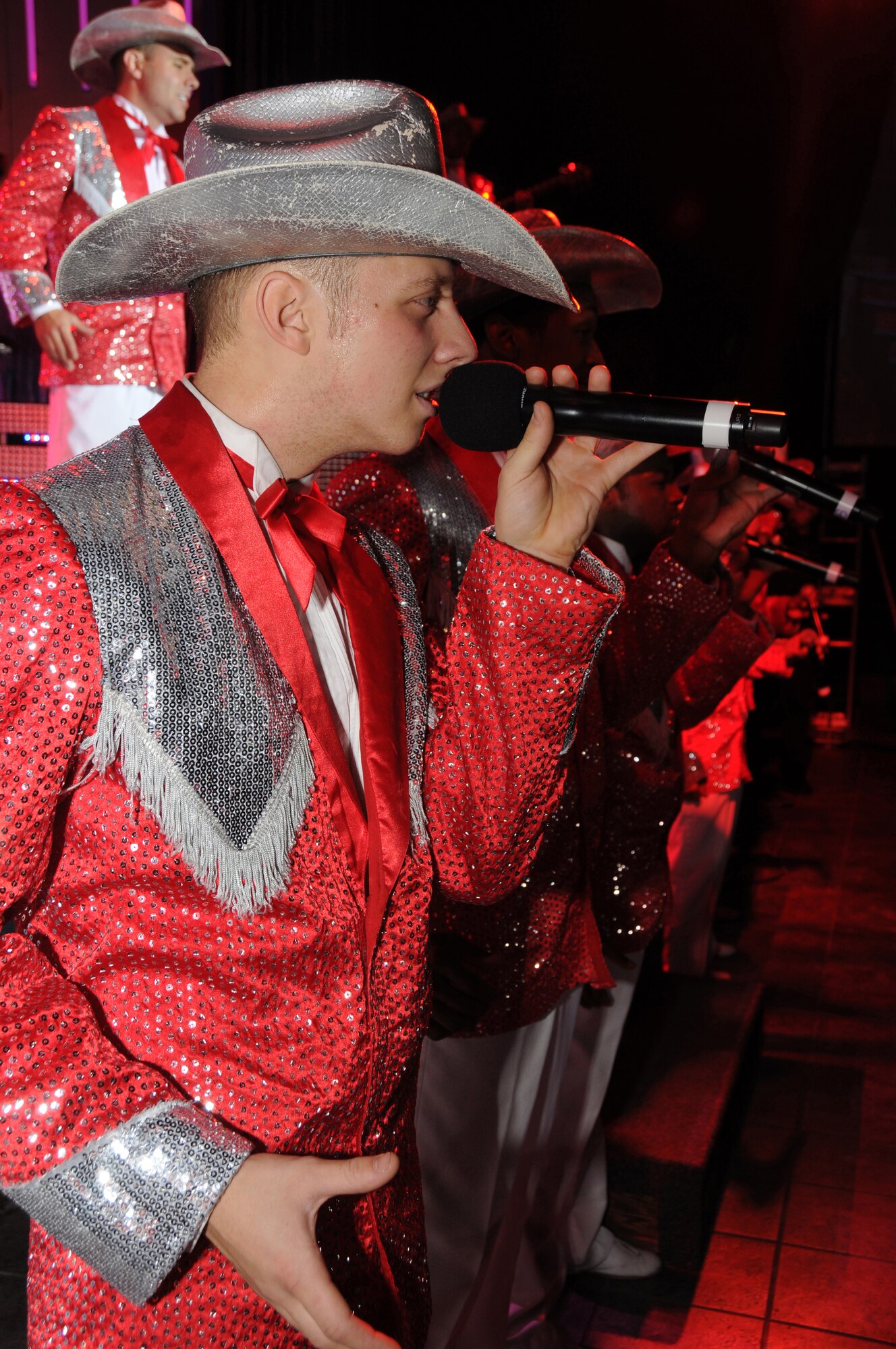 Airman 1st Class David Butler and Tops in Blue performers sing and dance during their annual world tour "Deja Blue" celebrating 55 years of entertainment Dec. 10, 2008, Eielson Air Force Base, Alaska.  Airman Butler is a Tops in Blue vocalist.  Tops in Blue entertains more than 250,000 military members and their families and perform's an average of 120 performances at 100 locations worldwide each year.   (U.S Air Force photo/Staff Sgt. Tia Schroeder)                                                                                                                                                                                                                                                                                                                           